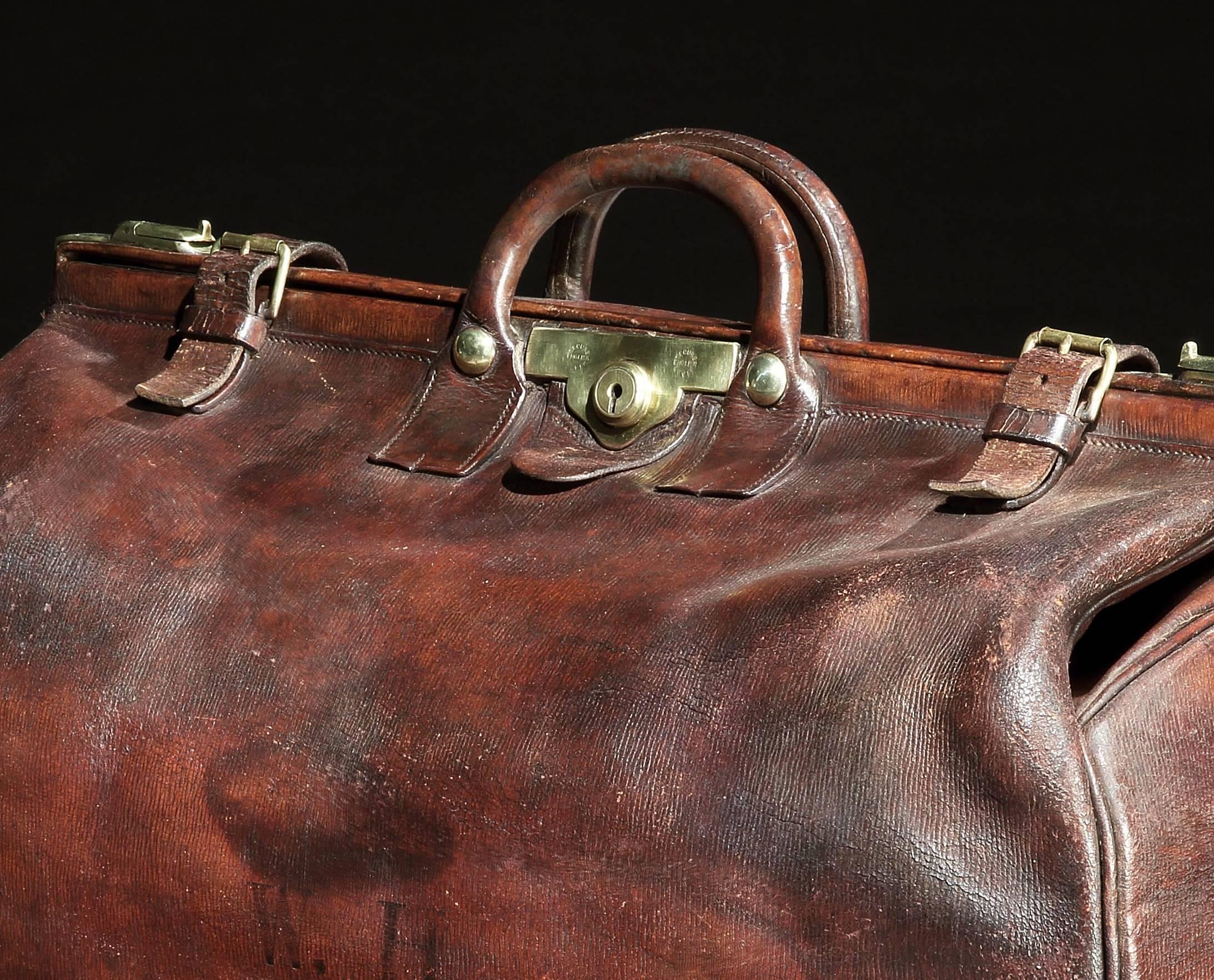 An incredibly large Edwardian, long-grain leather Gladstone bag, the deep glossy mahogany leather case with original straps, handle, buckles and secure English Lever locks, in incredibly good condition, the wide mouth locks open to reveal the