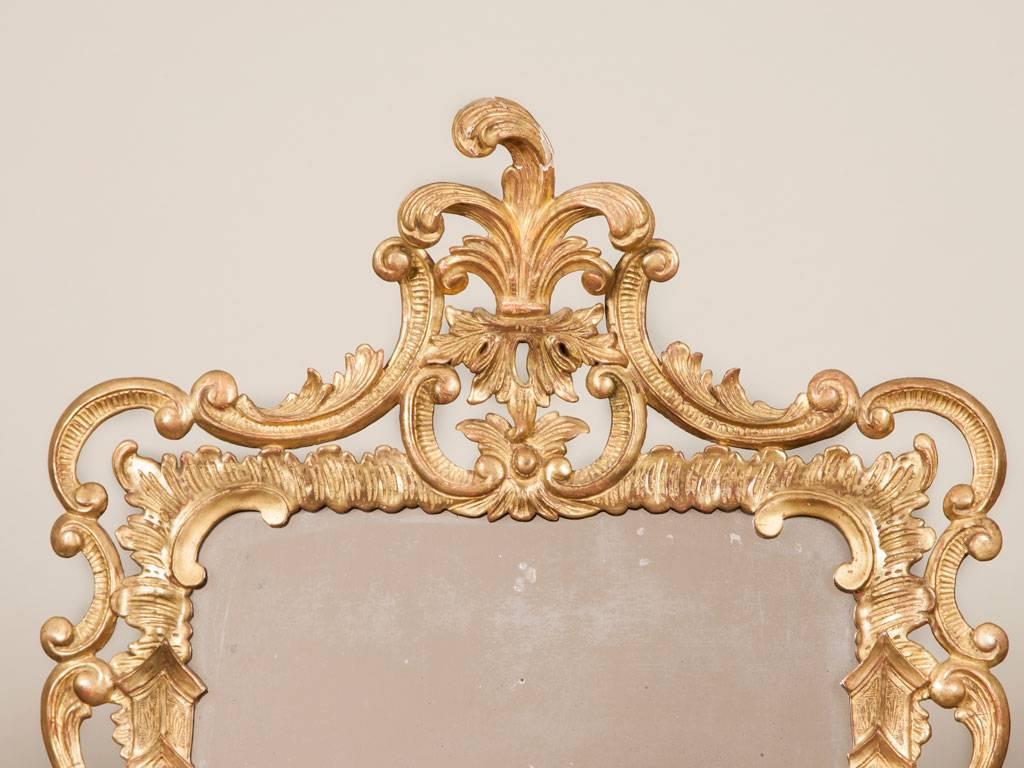 A George III rectangular mirror with a carved and gilded composition frame in
Rococo taste.