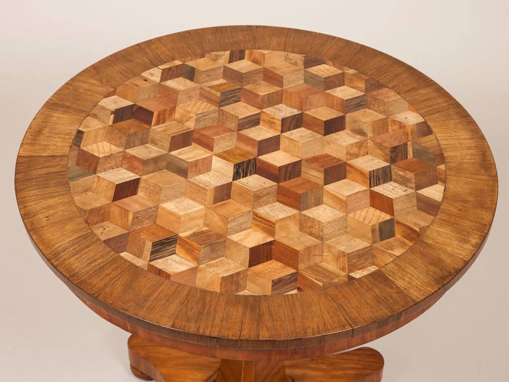 An early 19th Century tilt top table with a pedestal base and inlaid top.