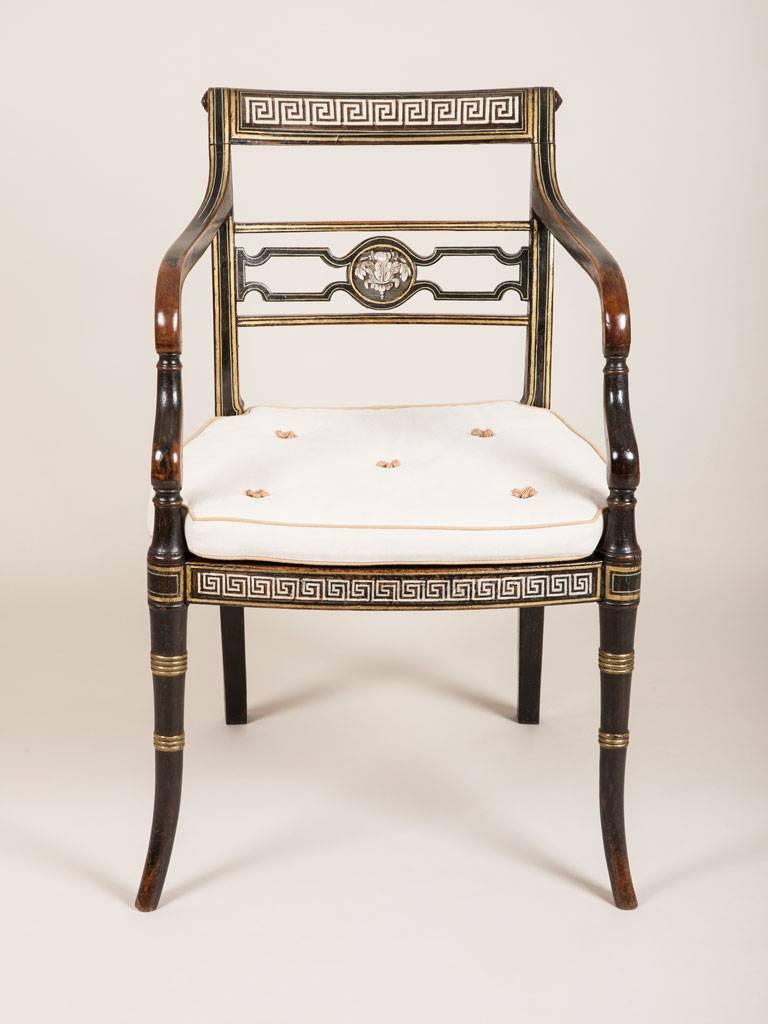A Regency black painted elbow chair with gilt neoclassical decoration,
circa 1820