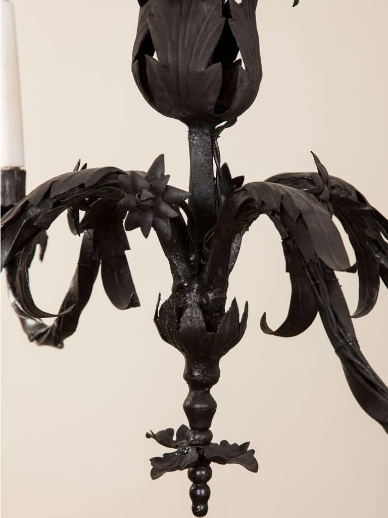 An early 19th century iron chandelier with four twisting branches and floral decoration.