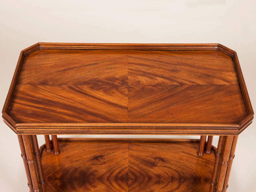 A two-tier mahogany low table with canted corners and simulated bamboo legs, by Madeleine Castaing.