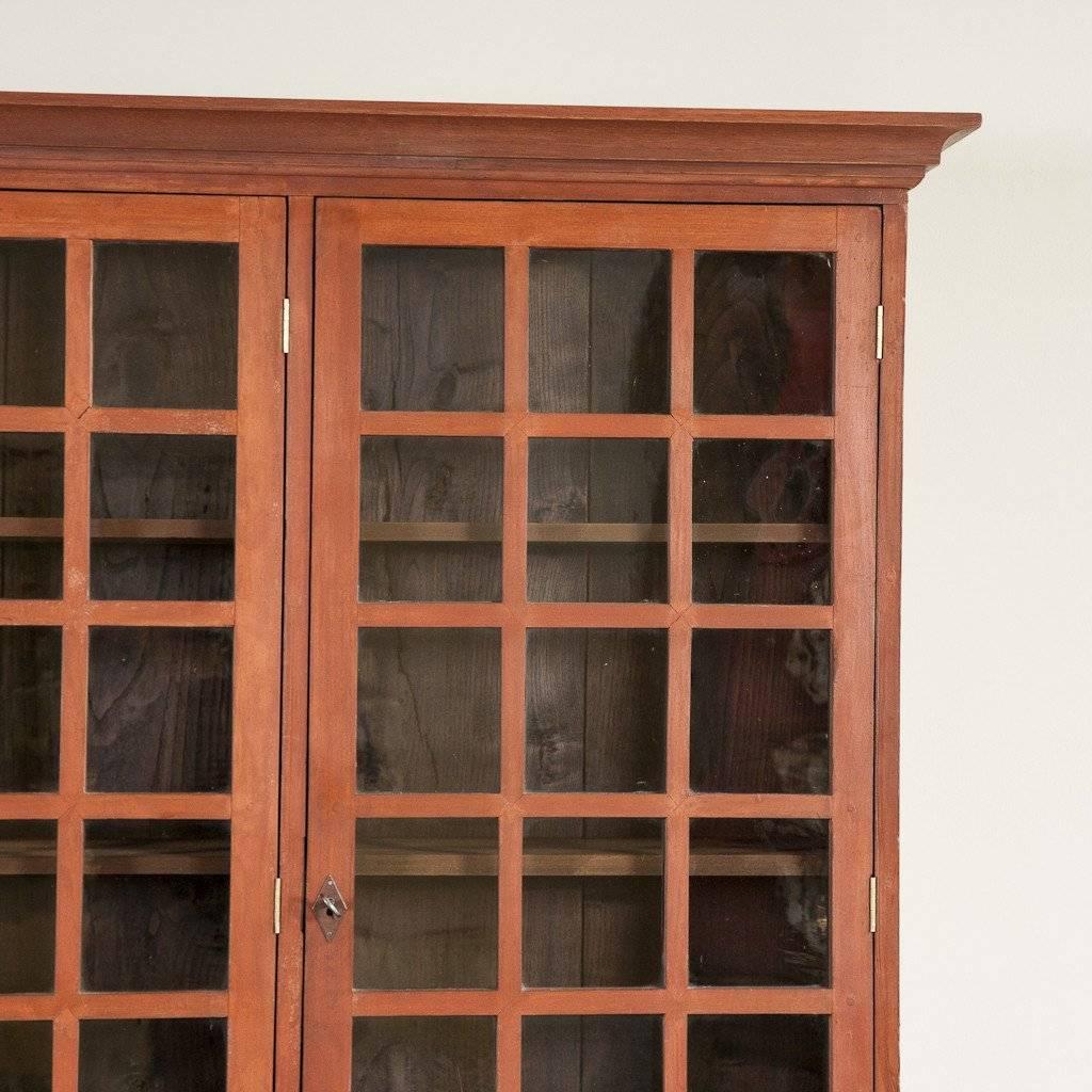 A painted bookcase of pleasing proportions with four square-glazed upper doors and simple panelled doors beneath, circa 1910, possibly Spanish. Original paint.