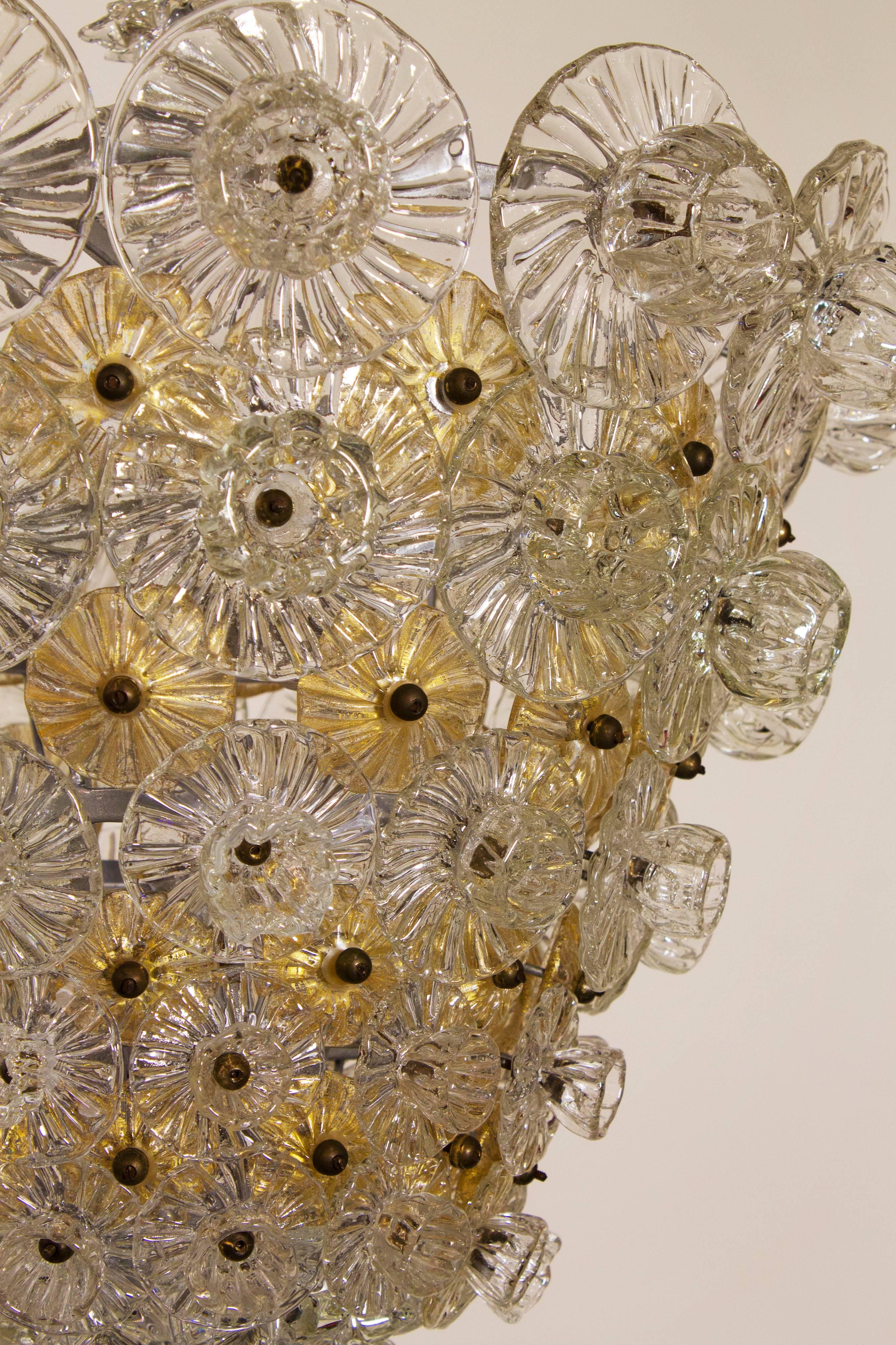 Murano chandelier comprised of stylized handblown flowers. The main flowers are clear glass with buds in pale gold.