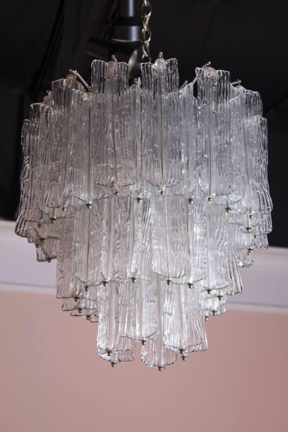 A stunning Italian chandelier brought to life by designer Toni Zuccheri in the 1950s. The clear handblown Murano glass is suspended by a multi-tiered nickel frame.