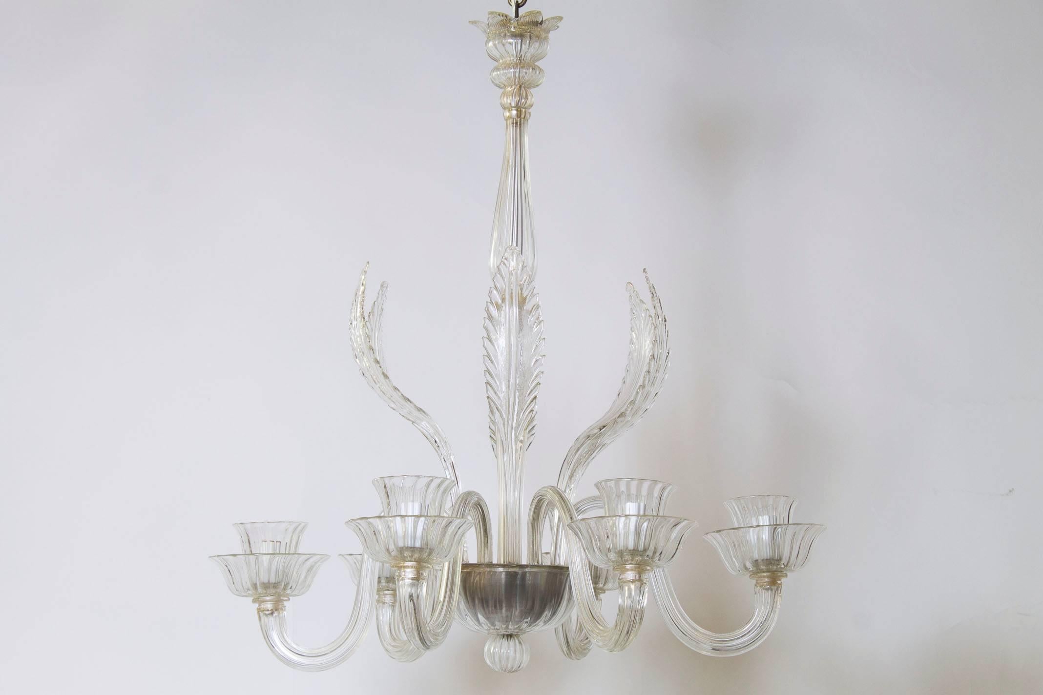 A traditional clear Murano chandelier, circa 1940.

Features six chandelier arms, six decorative glass feathers and a glass canopy with hints of soft gold.