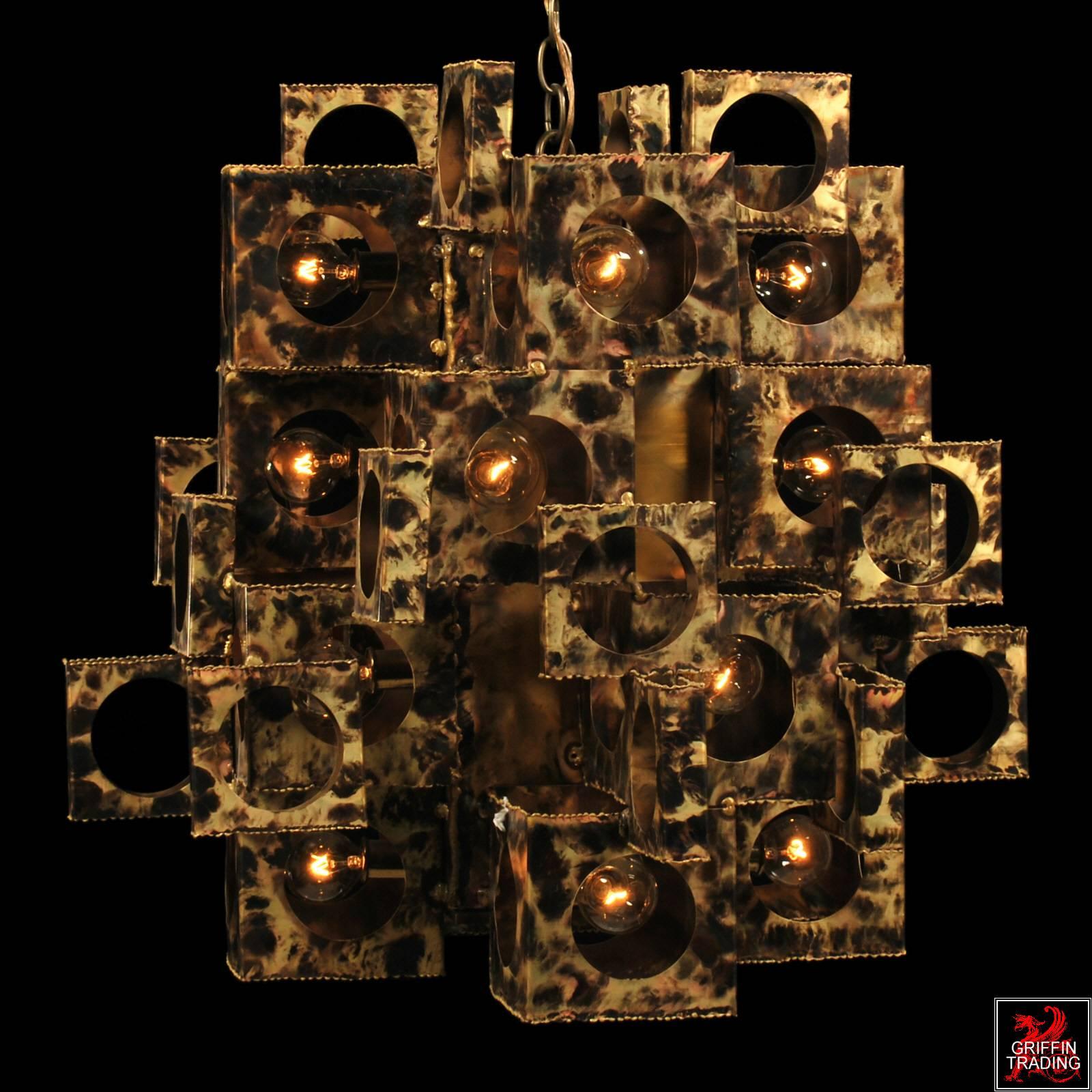 Here is another spectacular Brutalist chandelier by designer Tom Greene. This is one of the more rare forms with its unique cubist style. He used various sizes of torch cut boxes, which are layered and stair-stepped to create this dramatic