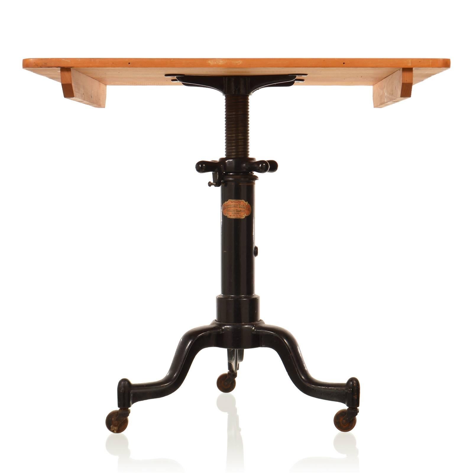 This is a marvelous antique table with a large flat groove screw base and tripod legs on steel casters. Made by the Adjustable Table Company of Grand Rapids, Michigan, this handsome 1890's industrial fixture was called the SATELLITE. Amazingly it