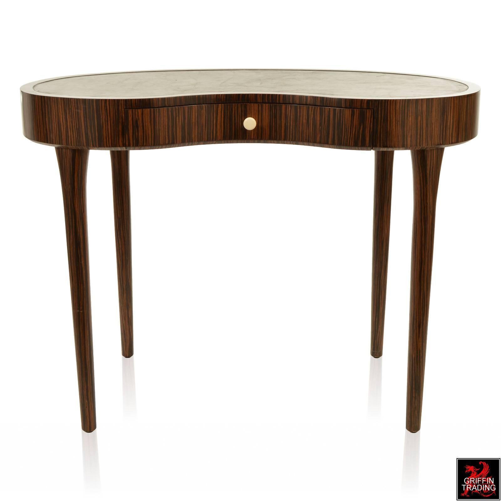 Stylish and sophisticated leather top writing desk with beautiful exotic wood grain veneer. This superb piece of furniture is extremely well made and has a classic look that will last a lifetime. The desk was designed by the Keno Brothers and made