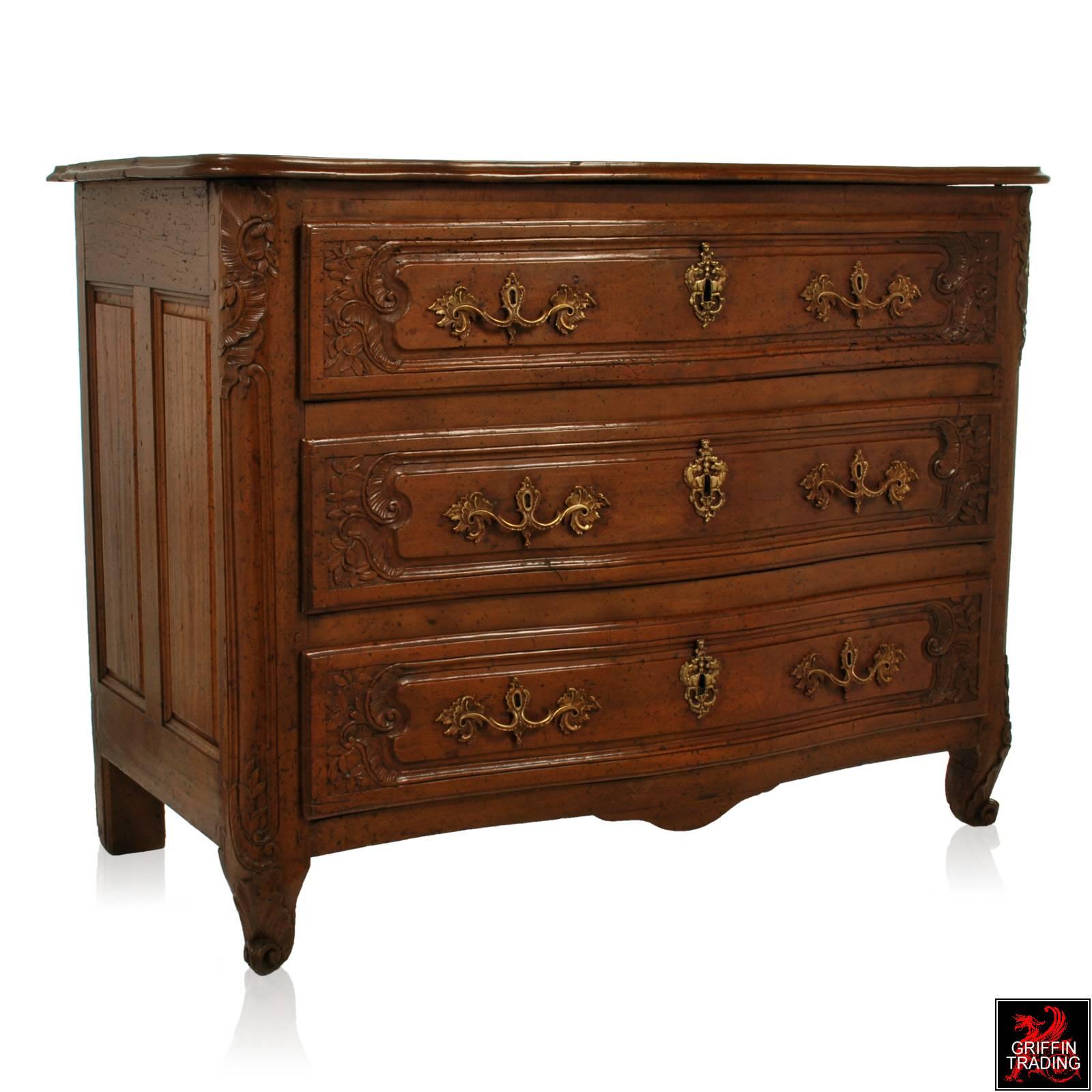 This handsome 18th century French Louis XV period three-drawer commode is taller and wider than most. The marvelous scale, serpentine shaped front with elaborate carving and rounded corners rest atop scroll feet. Made of solid walnut, this chest of