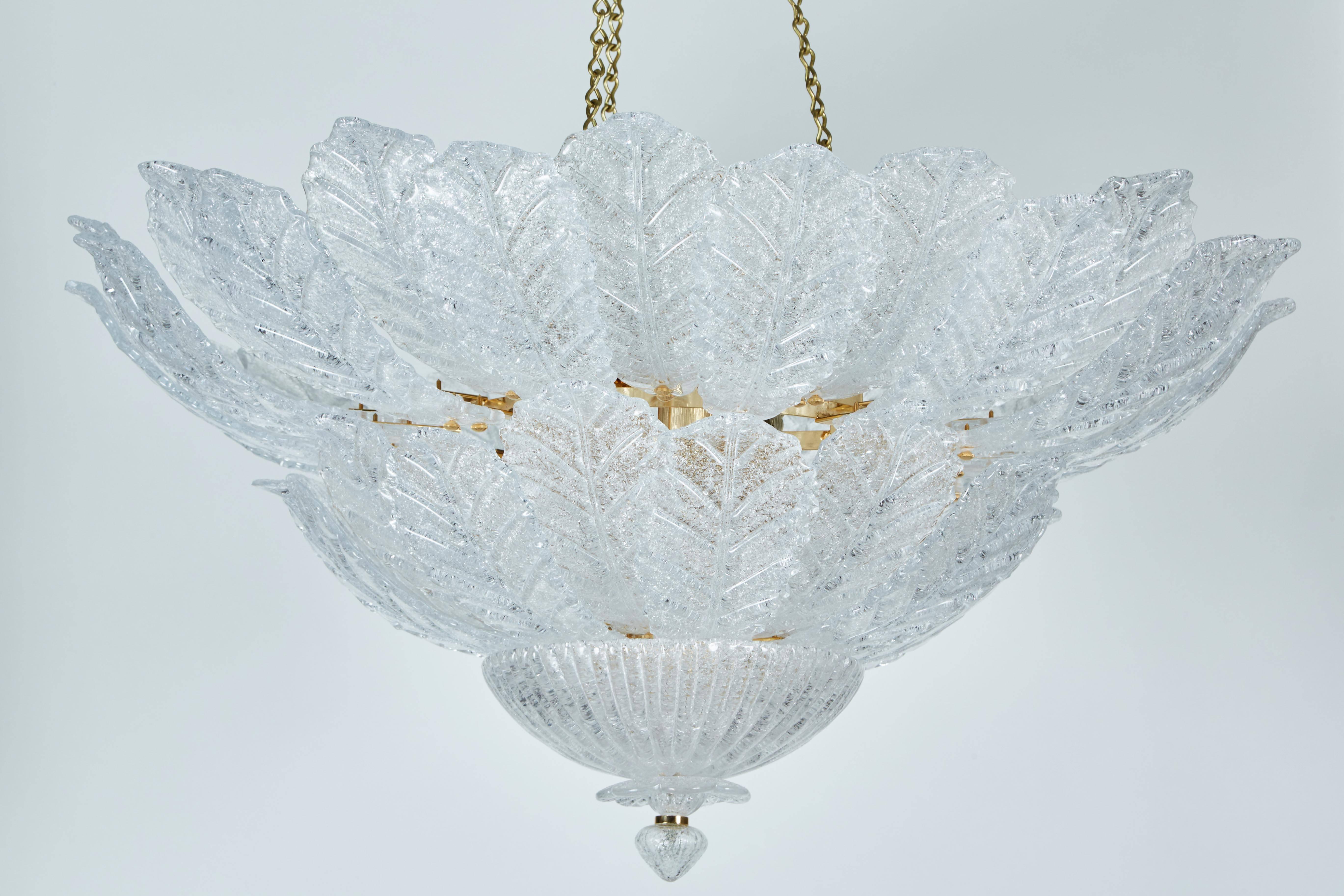 This Italian elegant chandelier with foliage design glass shapes held up by a brass fixture.