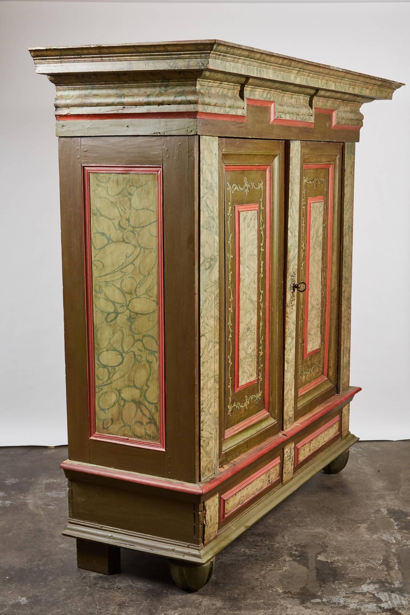 A unique hand painted cupboard from 18th century Denmark. Two door cabinet has baroque details of a faux green varigated marble overall. The legs and back are newer due to its being originally installed with in the plaster walls of a Manor House
