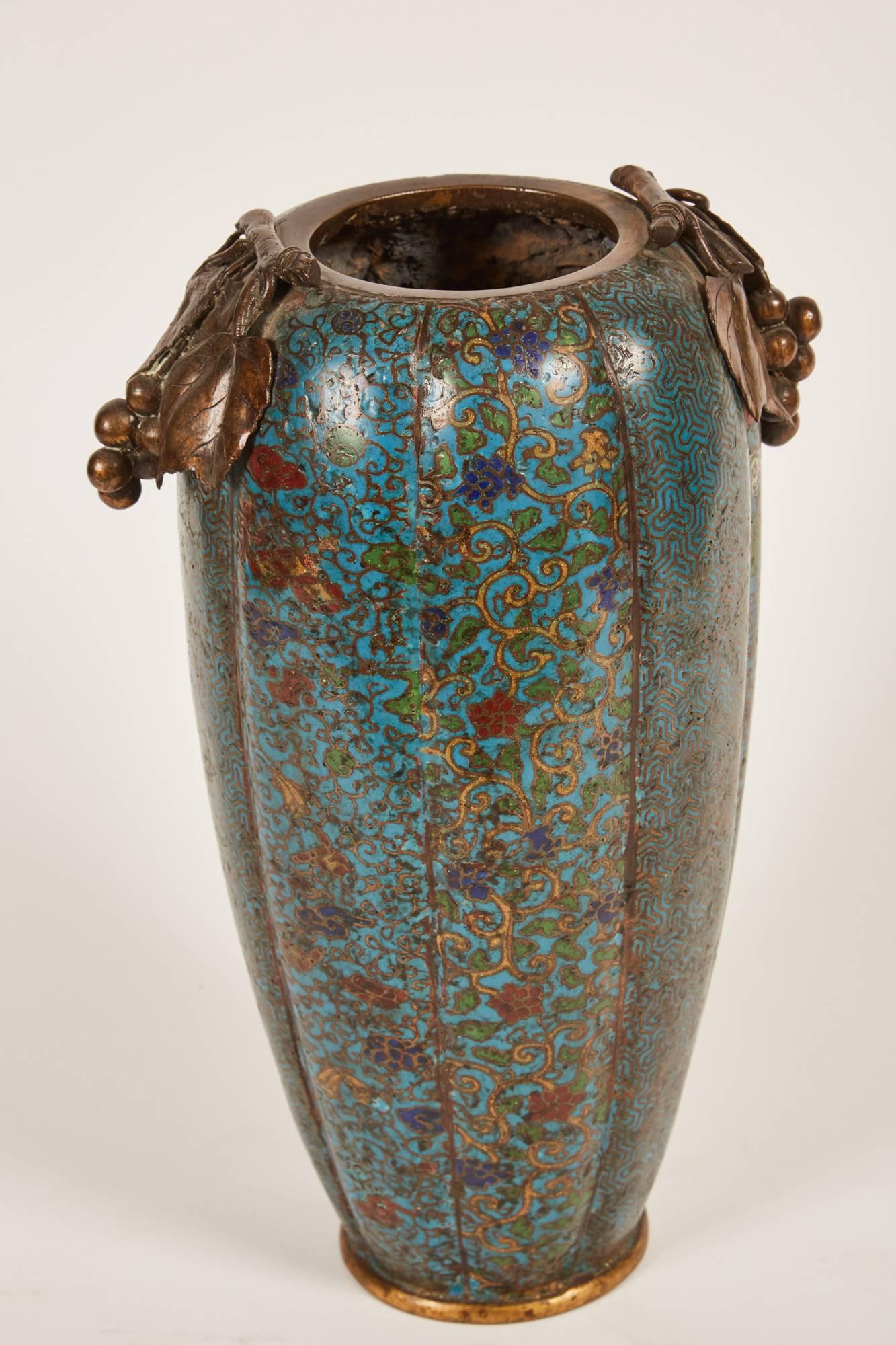 Impresionante jarrón chino de cloisonné del siglo XIX con asas que recuerdan hojas de parra y uvas. El propio jarrón está formado por motivos como mariposas y diversos diseños abstractos de follaje.
