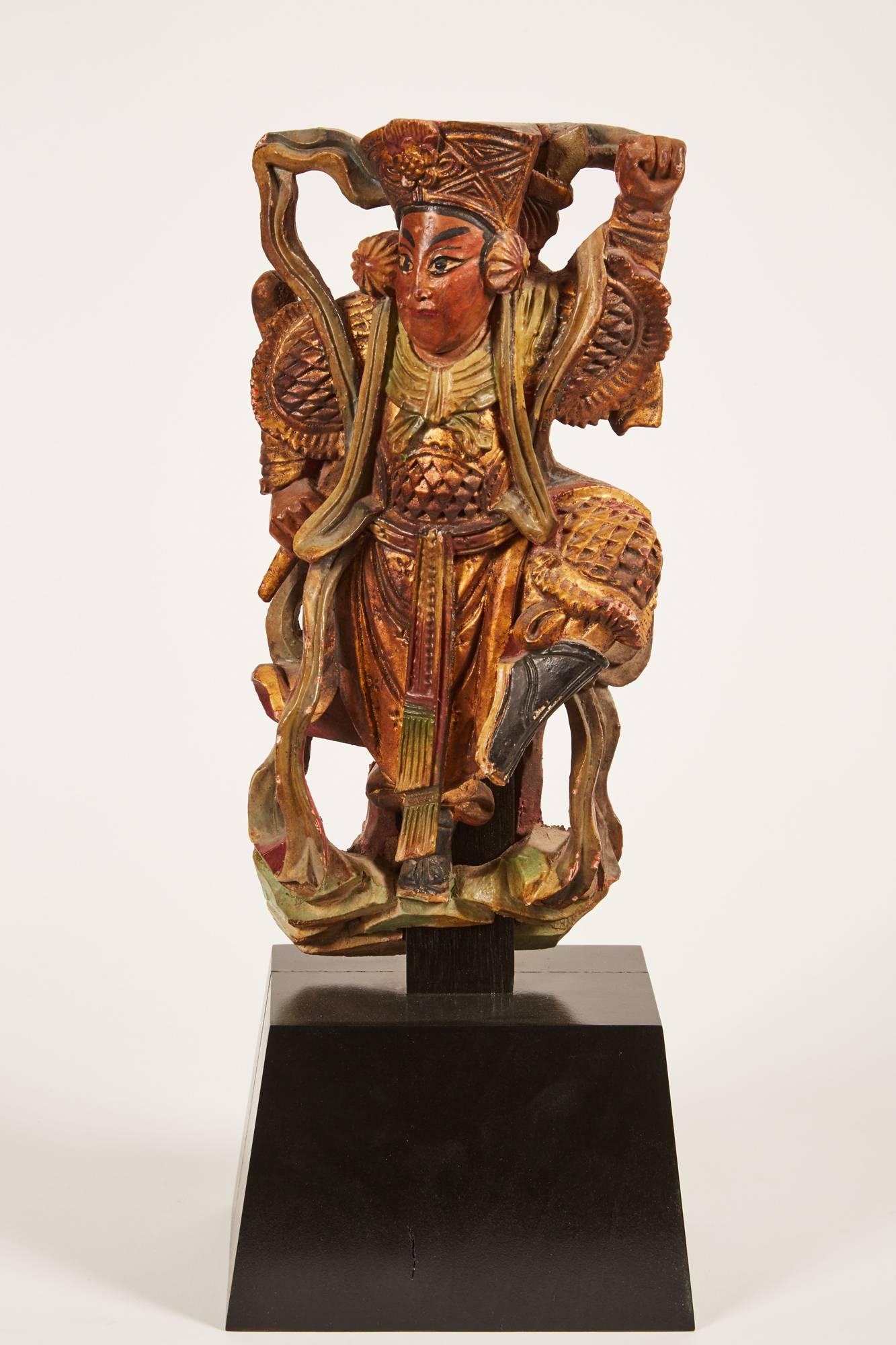 Carved wooden statue of Chinese Deities on stand. One has a long beard which appears to be wrapped and wound around his body in elaborate curling shapes, holding a long sword in his right hand, pointed to the floor. Painted in various shades of
