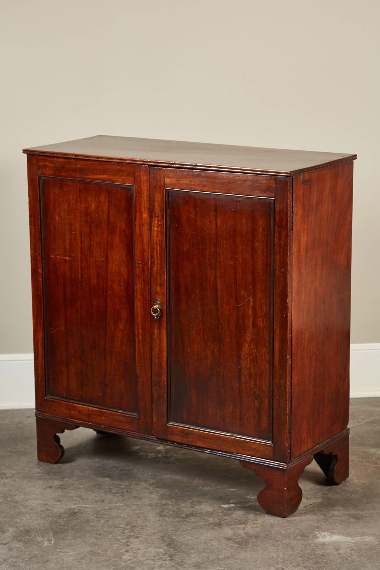 A unusual Georgian two-door side cabinet. The two solid doors open to reveal a compartment with four removable drawer trays.