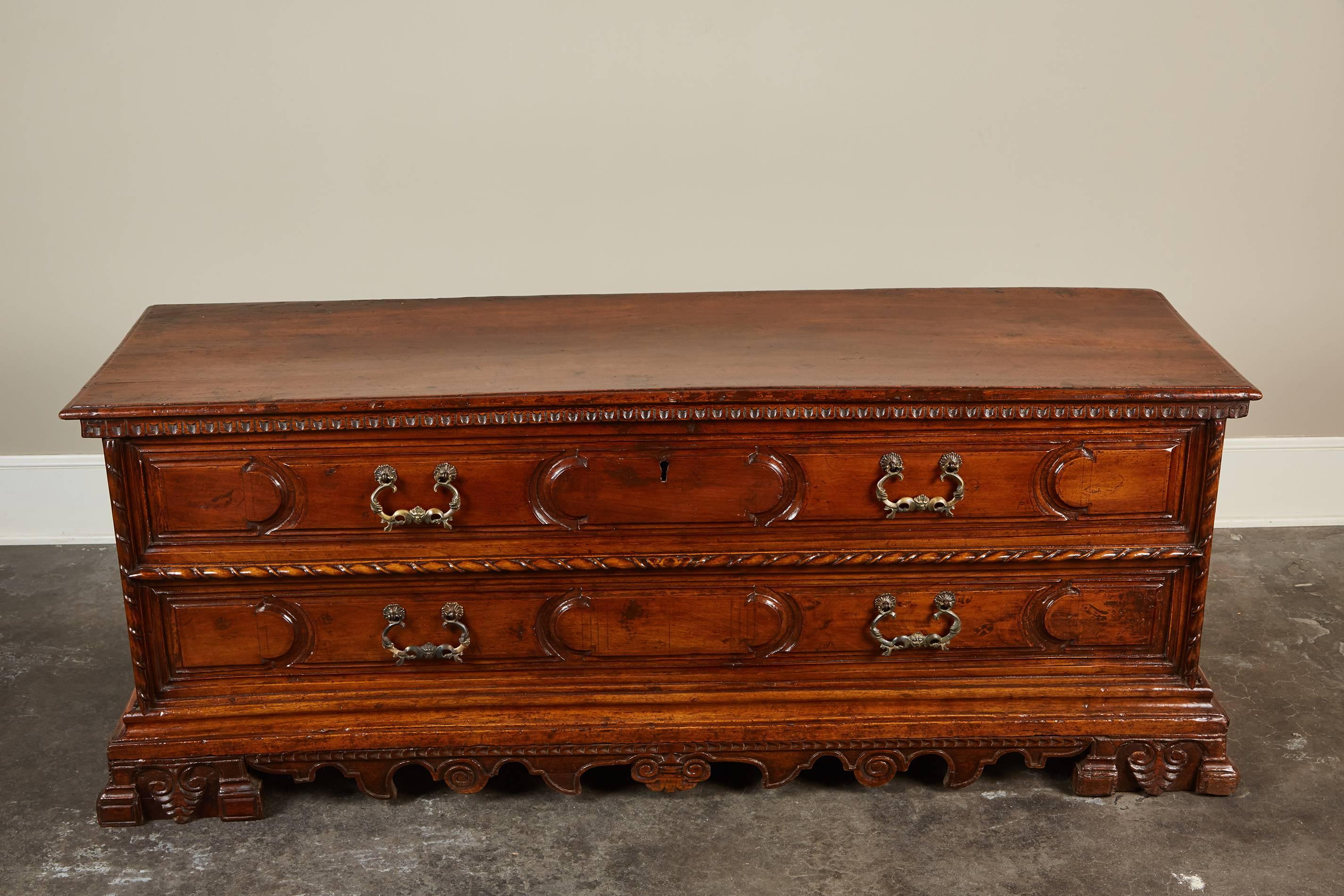 An early 19th century Italian walnut cassone with beautifully carved details with faux chest fronts. The cassone’s interior is covered in paper and has one compartment.