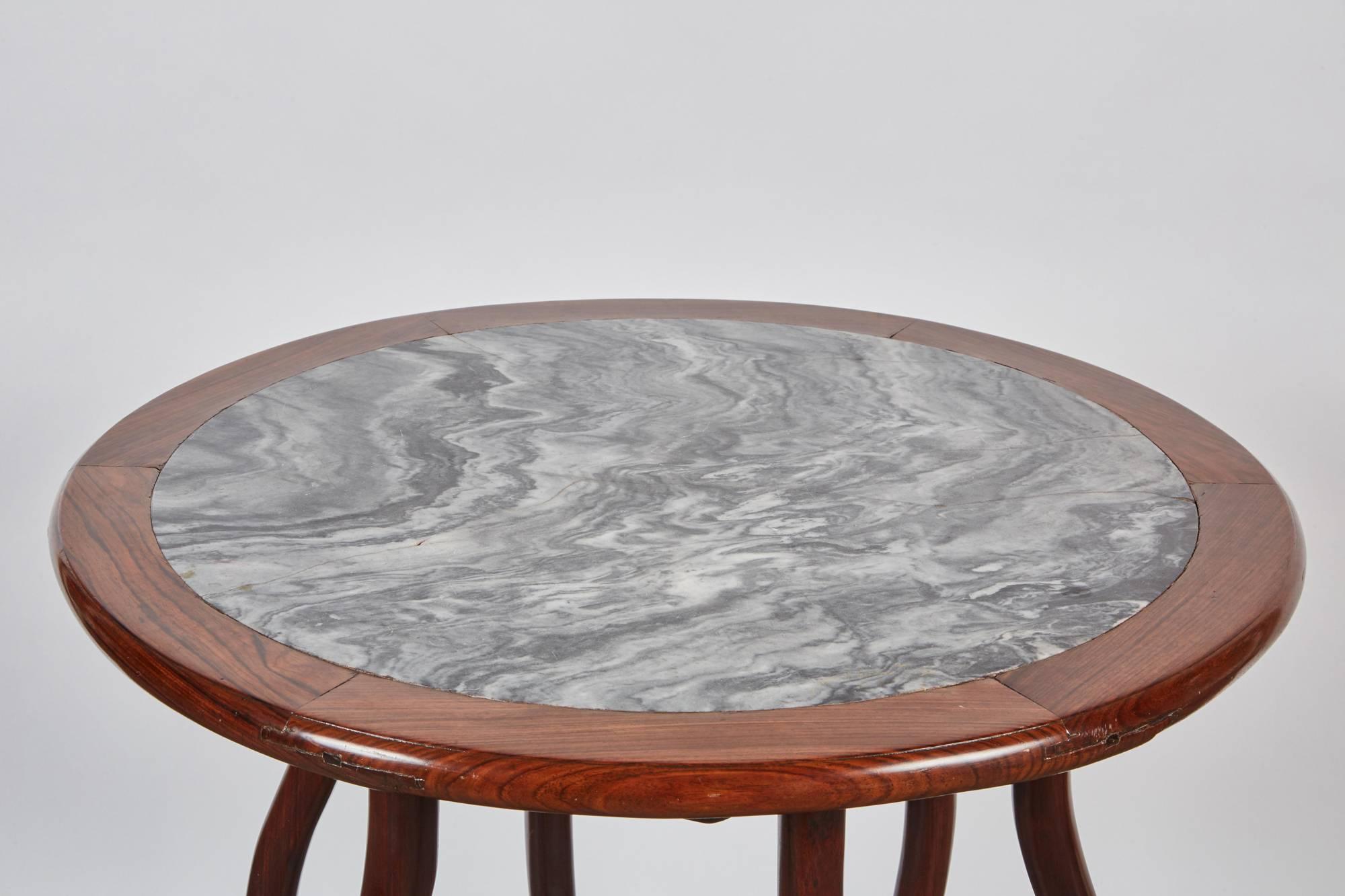 A two-piece folding table, from the Qing Dynasty, that has a rosewood base with a white and gray marble detachable tabletop. This late 19th century Chinese round rosewood folding table also features a set of six uniquely shaped legs.