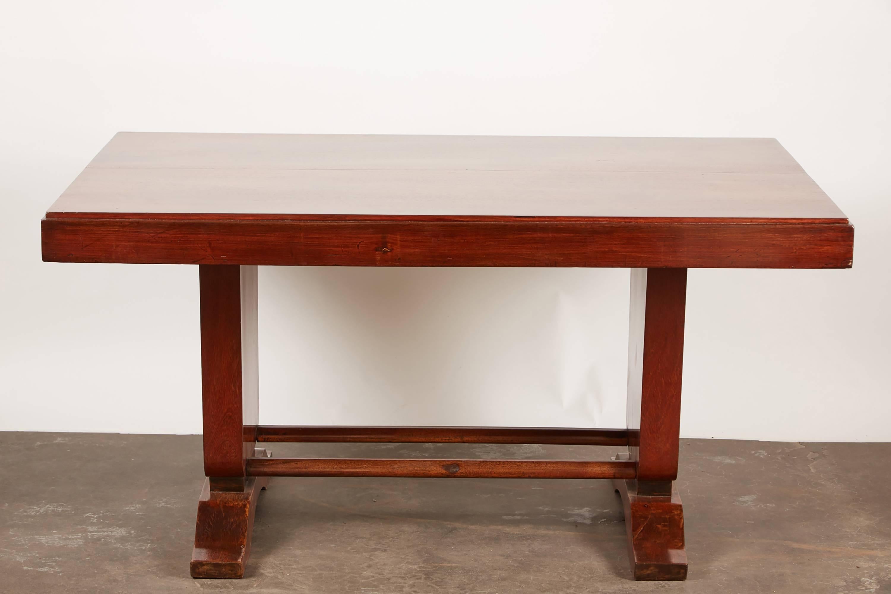 20th century French Colonial Art Deco rosewood desk on two pedestal legs. Rosewood is not veneered, rather it is cut and wide enough cover each span.