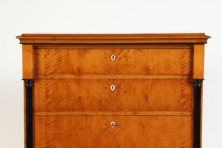 A Biedermeier chest of drawers, dated, circa 1810, Swedish and made in birchwood. The key hole covers are inlaid in bone, and the five drawers are all lined in red silk. The height of the drawers increases gradually, and the deepest drawer is on the
