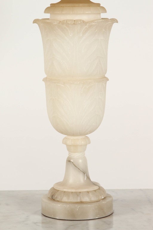 An Italian alabaster lamp created in the early 20th Century. The base of this Italian lamp is carved in two levels of climbing leaves and finished at the bottom with a row of round bead shaped carvings.  Sold without shade.