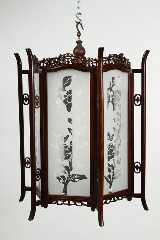 A pair of 19th Century Chinese lanterns in glass and rosewood. Each of the glass side panels of these 19th Century lanterns is etched in a pattern of flowers and leaves. The rosewood frames are elaborately carved. The lanterns are suspended via hook