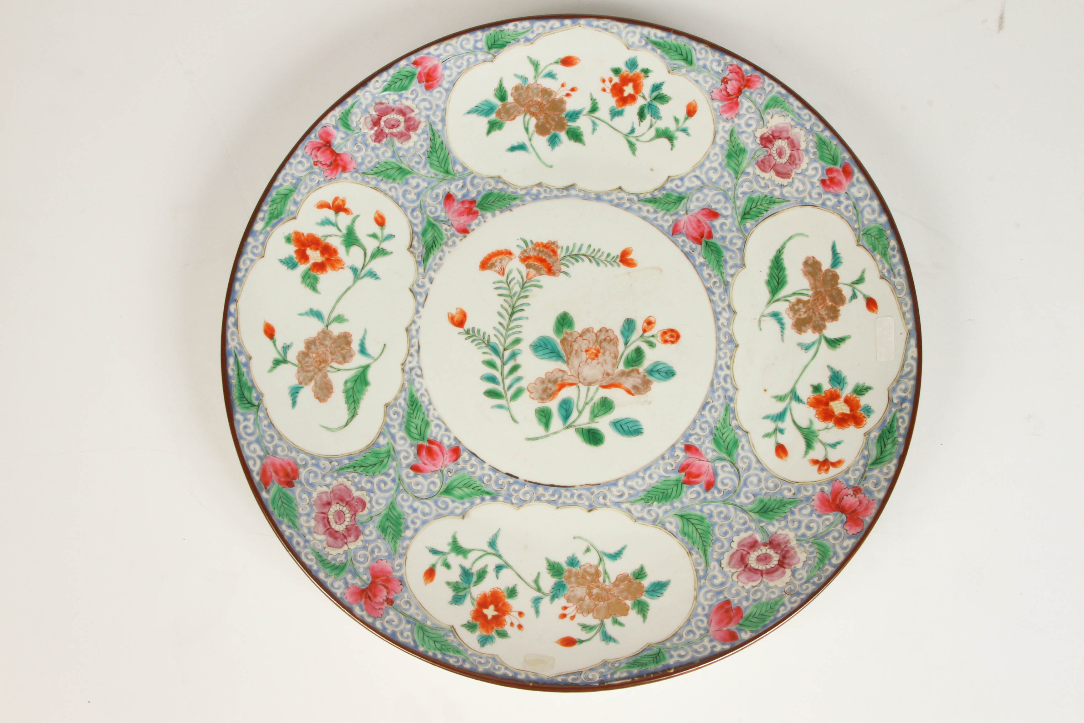 A large porcelain charger marked made in China for the Malaysian Market in the 19th century. The center of this charger is printed in a circular floral motif and there are similar delicate floral motifs around the perimeter.