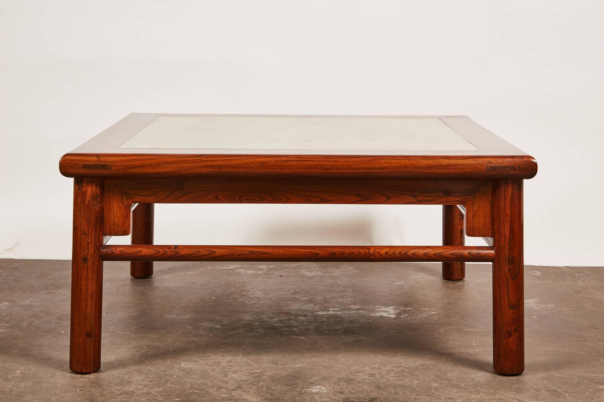 A 20th century Ming style elm coffee table. The table features clean and simple lines with a tabletop that has a center consisting of a green stone.