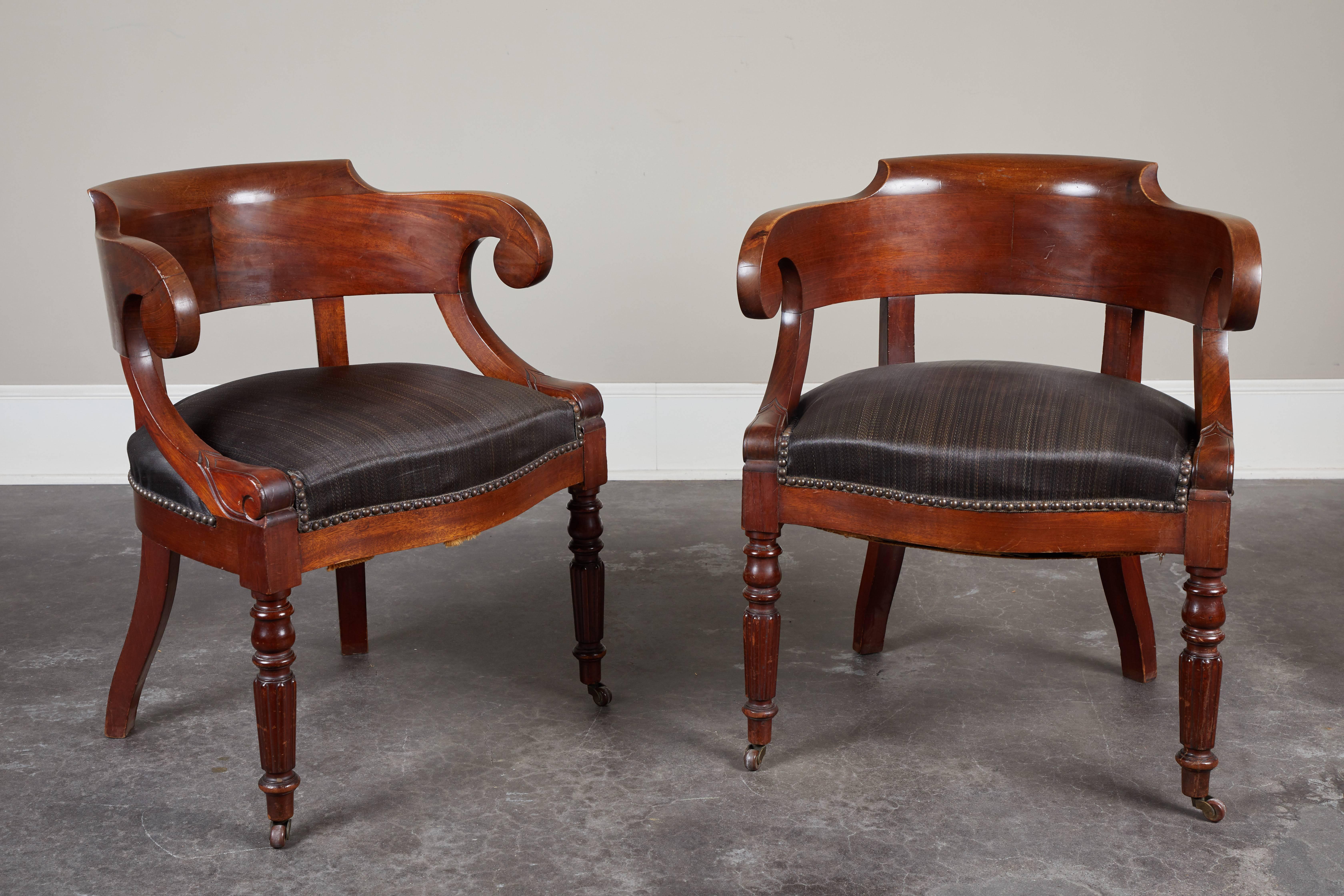 A handsome pair of Swedish mahogany armchairs, with concave back, inscrolled arms and turned front legs, circa 1850. Seats are upholstered in real horsehair with nailhead finishing.