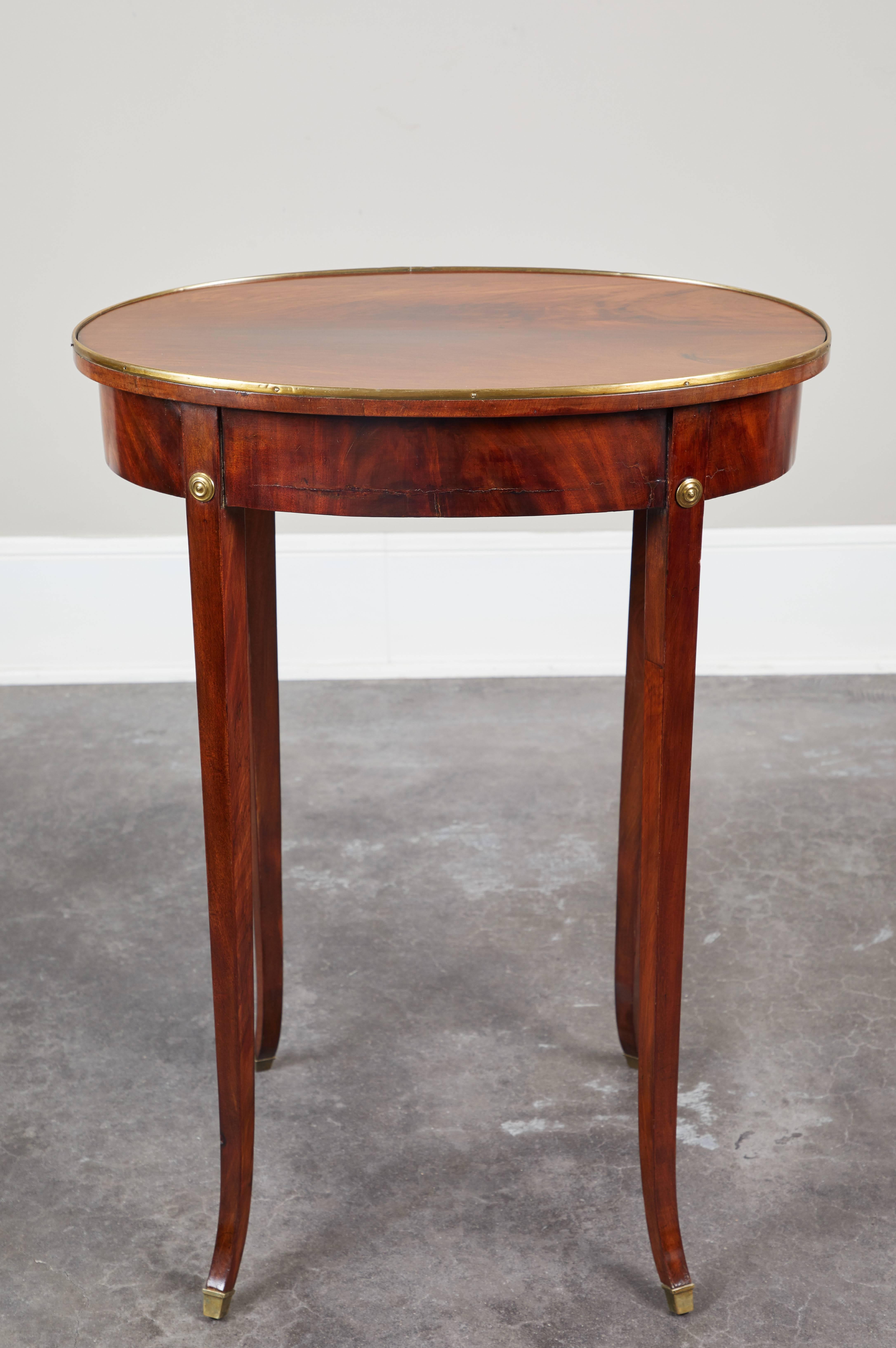 A lovely pair of Swedish Gustavian mahogany side tables, circa 1810 or earlier.  Oval top on four splayed, thin legs featuring brass details.