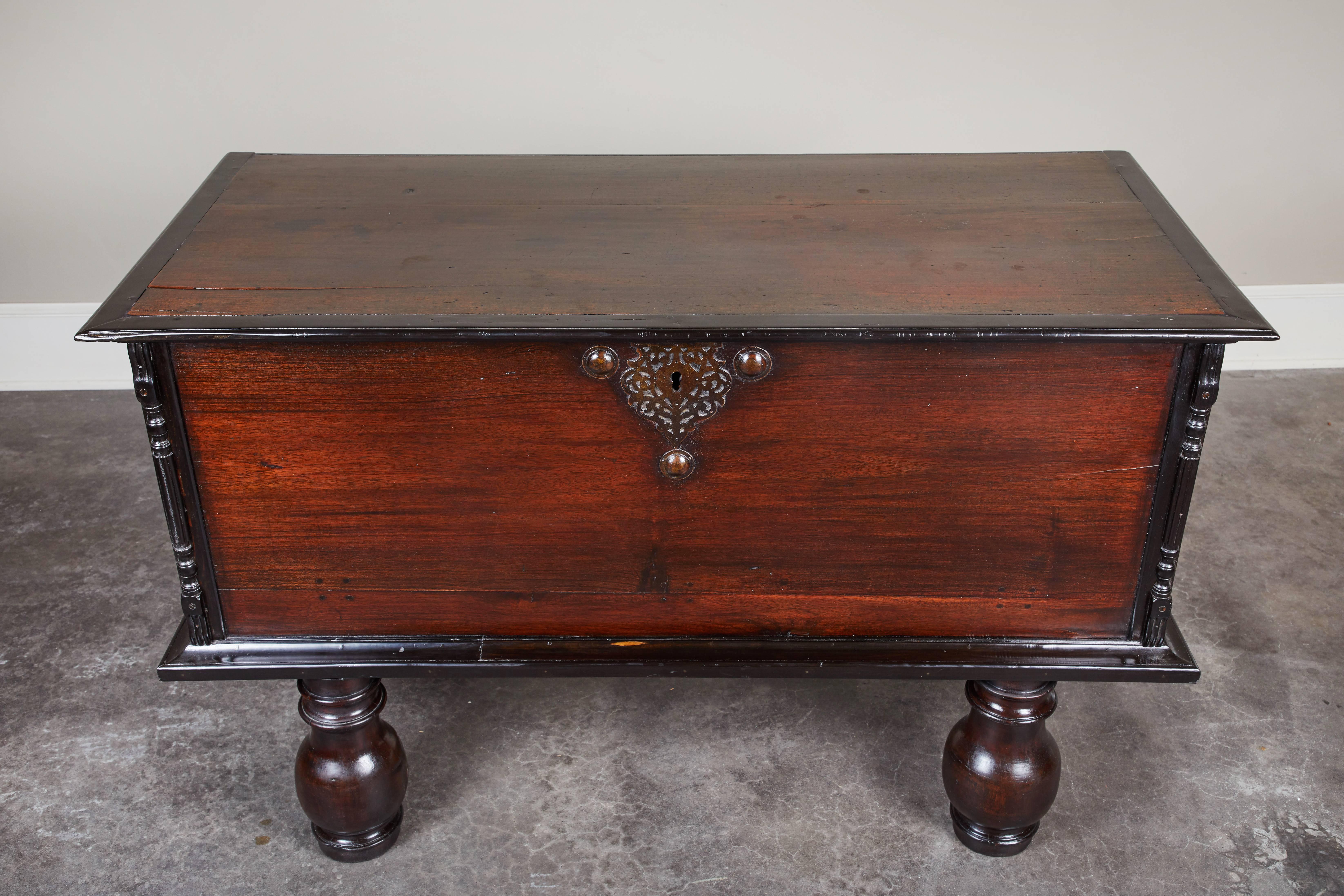 A 19th century British Colonial trunk comprised of jakwood and ebony. The trunk features a central hardware piece and carved columns on the sides. 