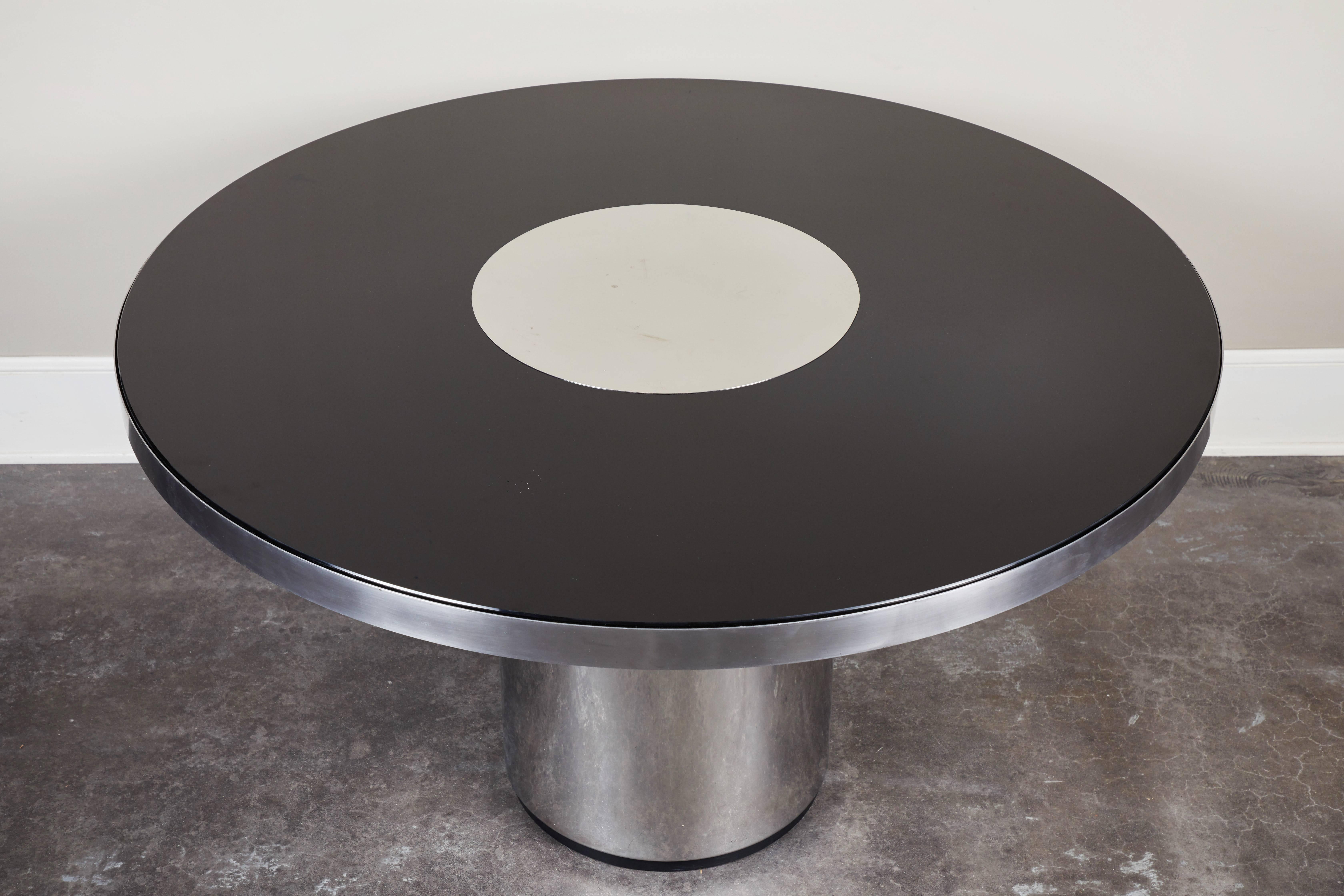 Brueton style round steel and glass table. Brueton's uncompromising attention to detail combine with the visual continuity of this design to create a simple yet unique table. Tops of different materials float over a seamless metal apron.  Similar
