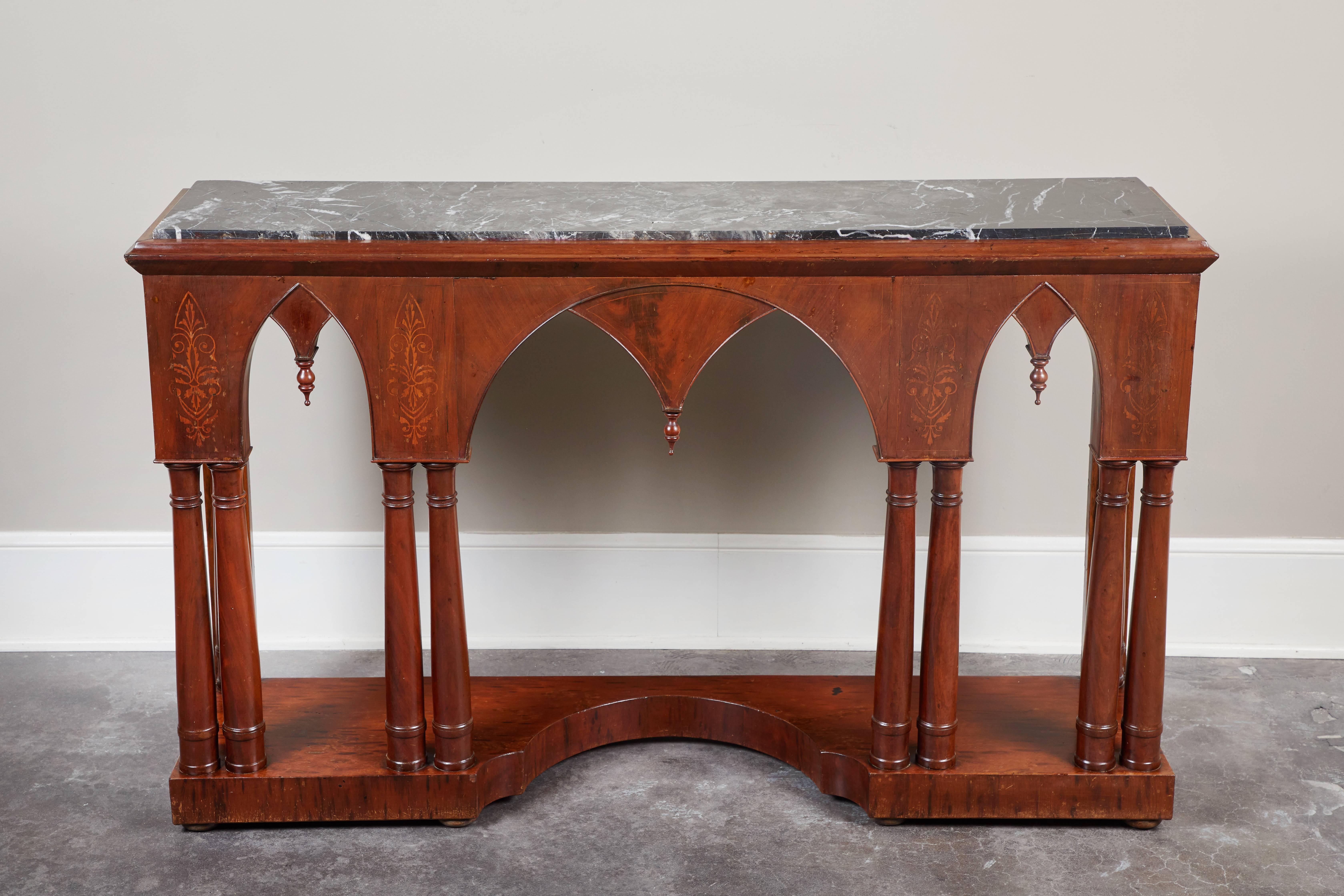 A gothic style French Charles X mahogany console, circa 1840. Black marble top, with bottom featuring a platform base with gothic arches.