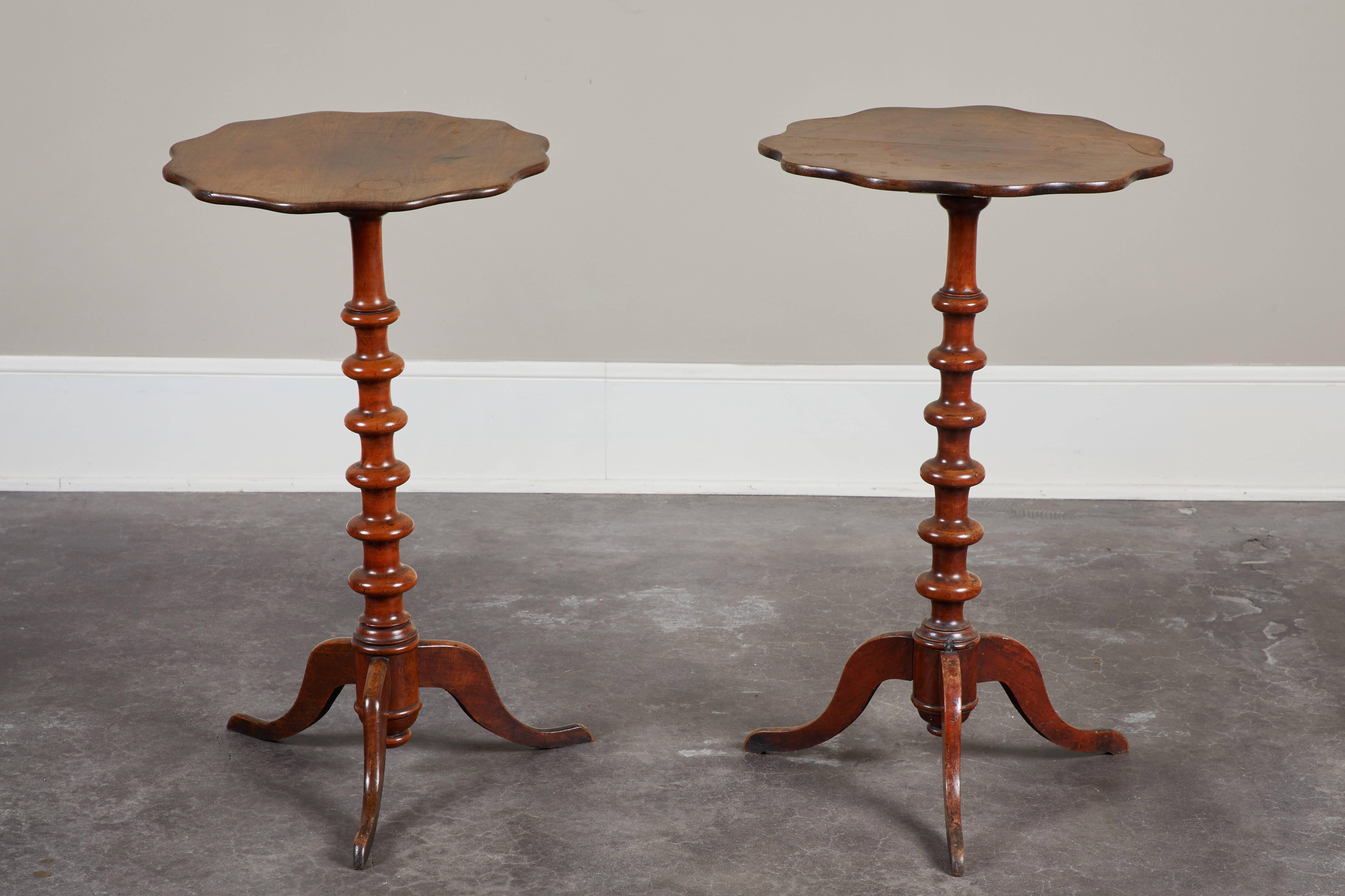 A delicate pair of Swedish walnut side tables, with slender carved pedestal column which that is raised upon delicately sloped tripod feet, circa 1860.  Gently scalloped shaped top.