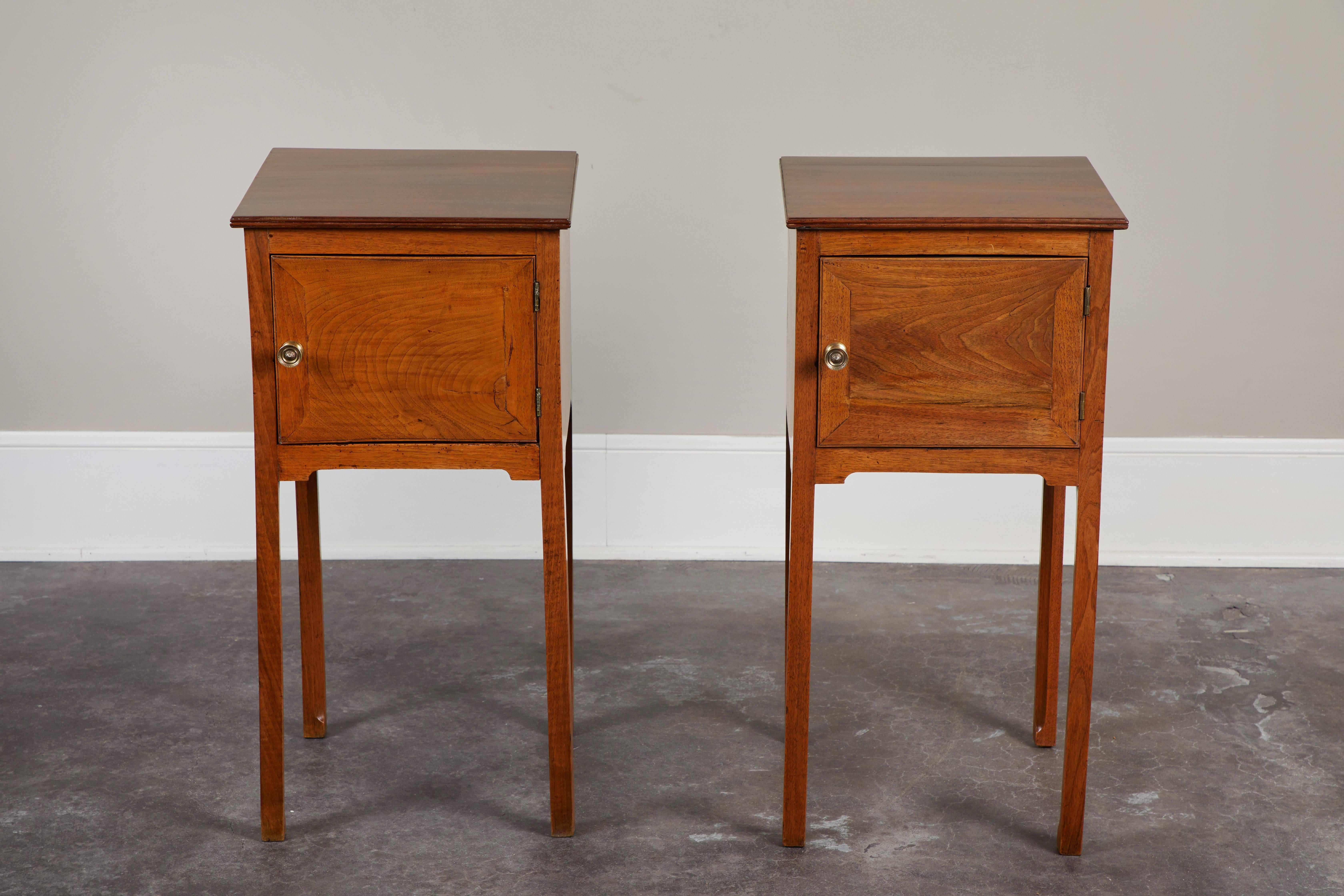 A pair of early 19th century George III English walnut side tables with front single door.  Simple, square shape compliments most design aesthetics, and a handsome pair makes it easy to decorate in nearly any room.