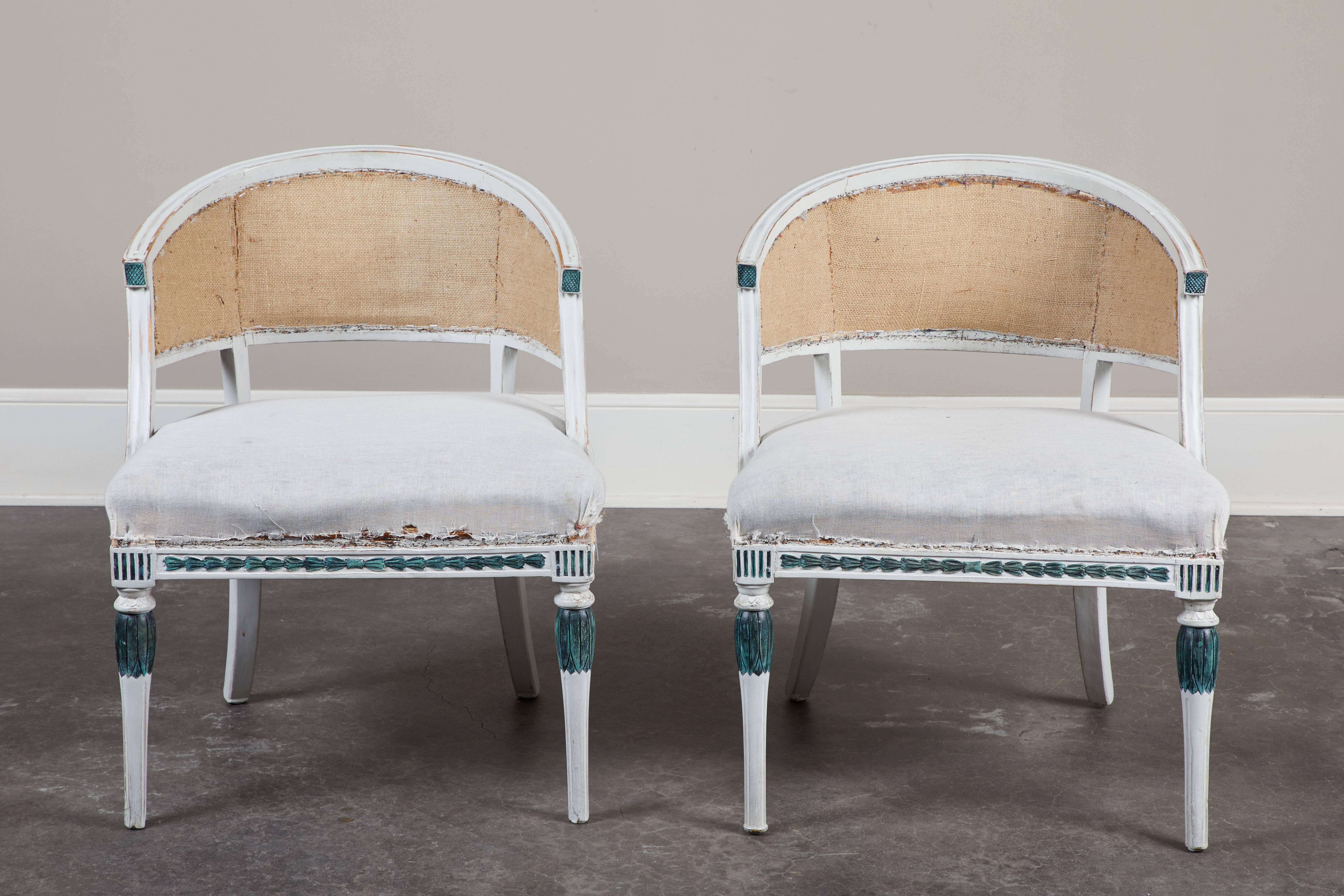 A light colored painted pair of Swedish Gustavian barrel back armchairs, circa 1810.