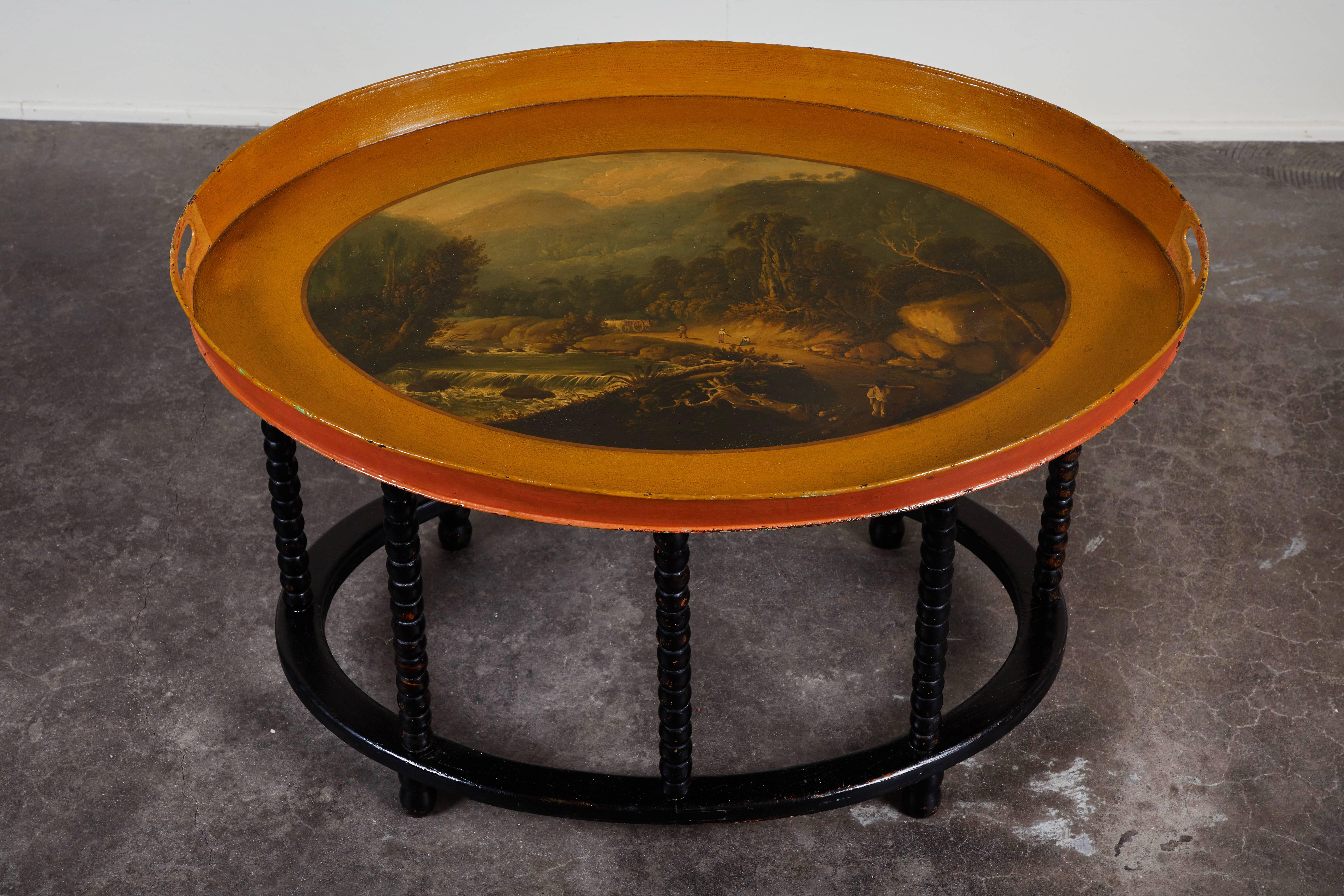 A Danish tole tray table, featuring a West Indies motif and a newer stand, circa 1835.  Stand features the ever-popular bobbin style legs in a gorgeous black, drawing attention to the colorful and intricately painted tray top.