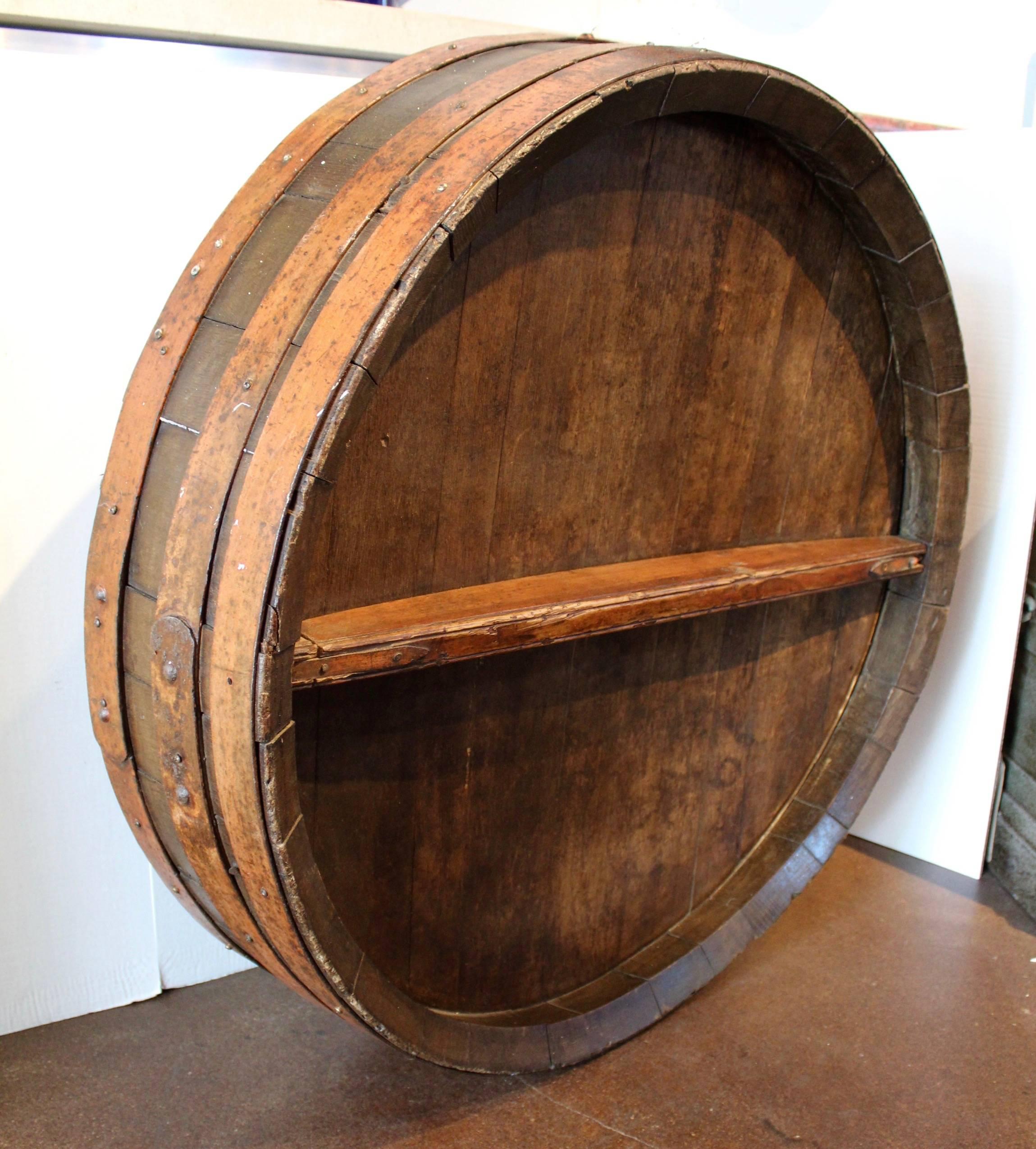 Antique French iron banded orange wine barrel as wall decor, circa 1880.
Original distressed orange patina on iron banded wine cask.
Primitive dark wood antique brown natural patina. 
Wine cask face is from Normandy, known for their white wines:
