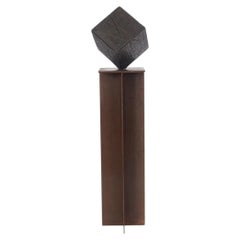 Scultura a forma di cubo in bronzo su piedistallo in acciaio con finitura ruggine