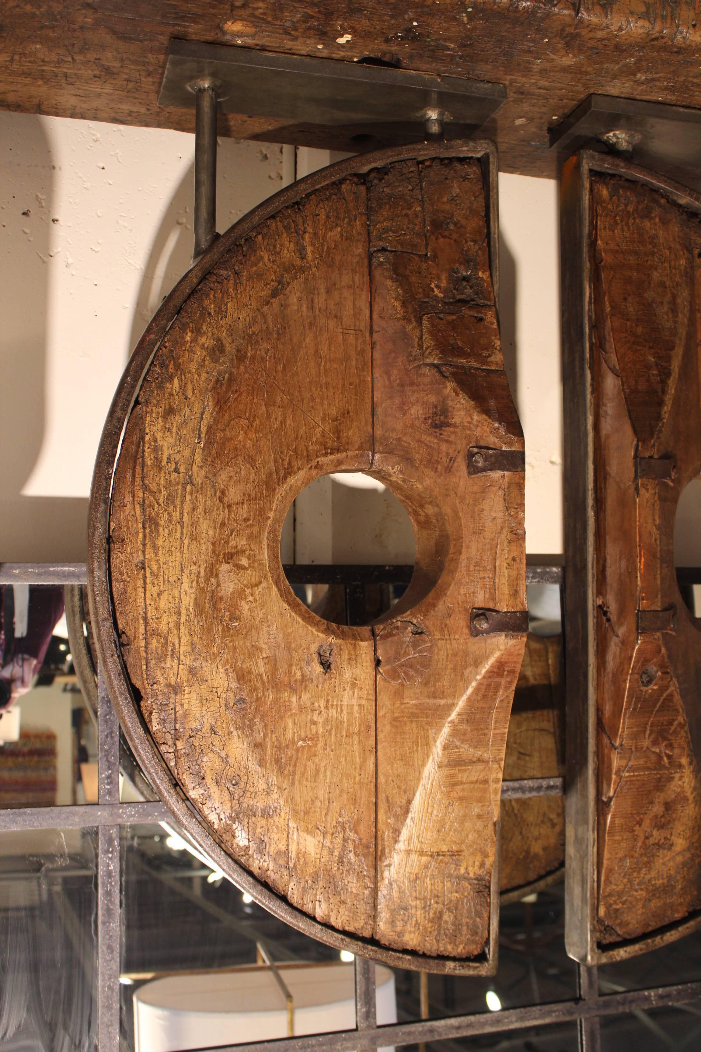 Spanish 19th century elm and iron wheel as sculptural expression on custom iron mount.
