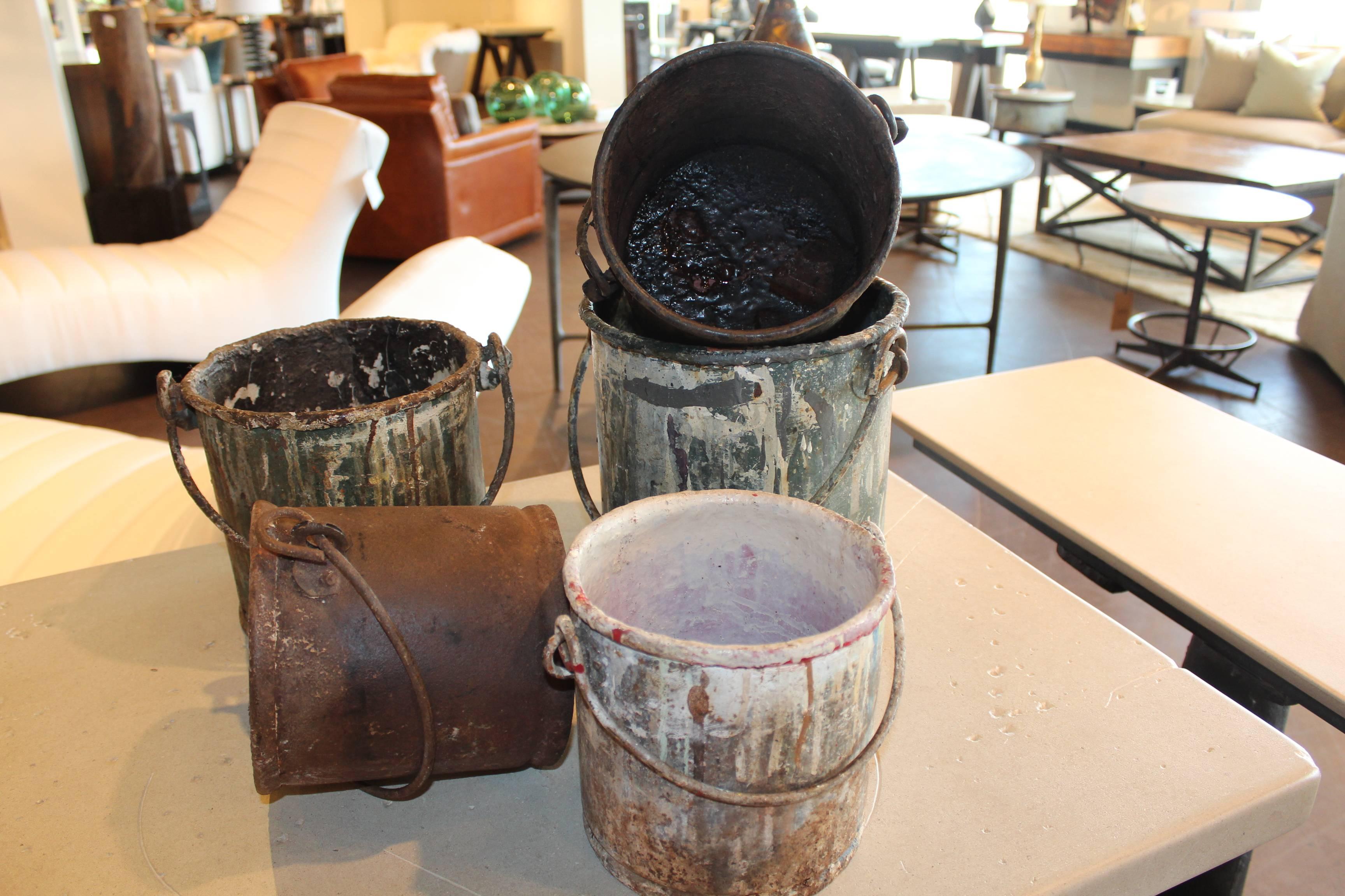 Vintage metal paint buckets from the last century, repurposed as table accessory.