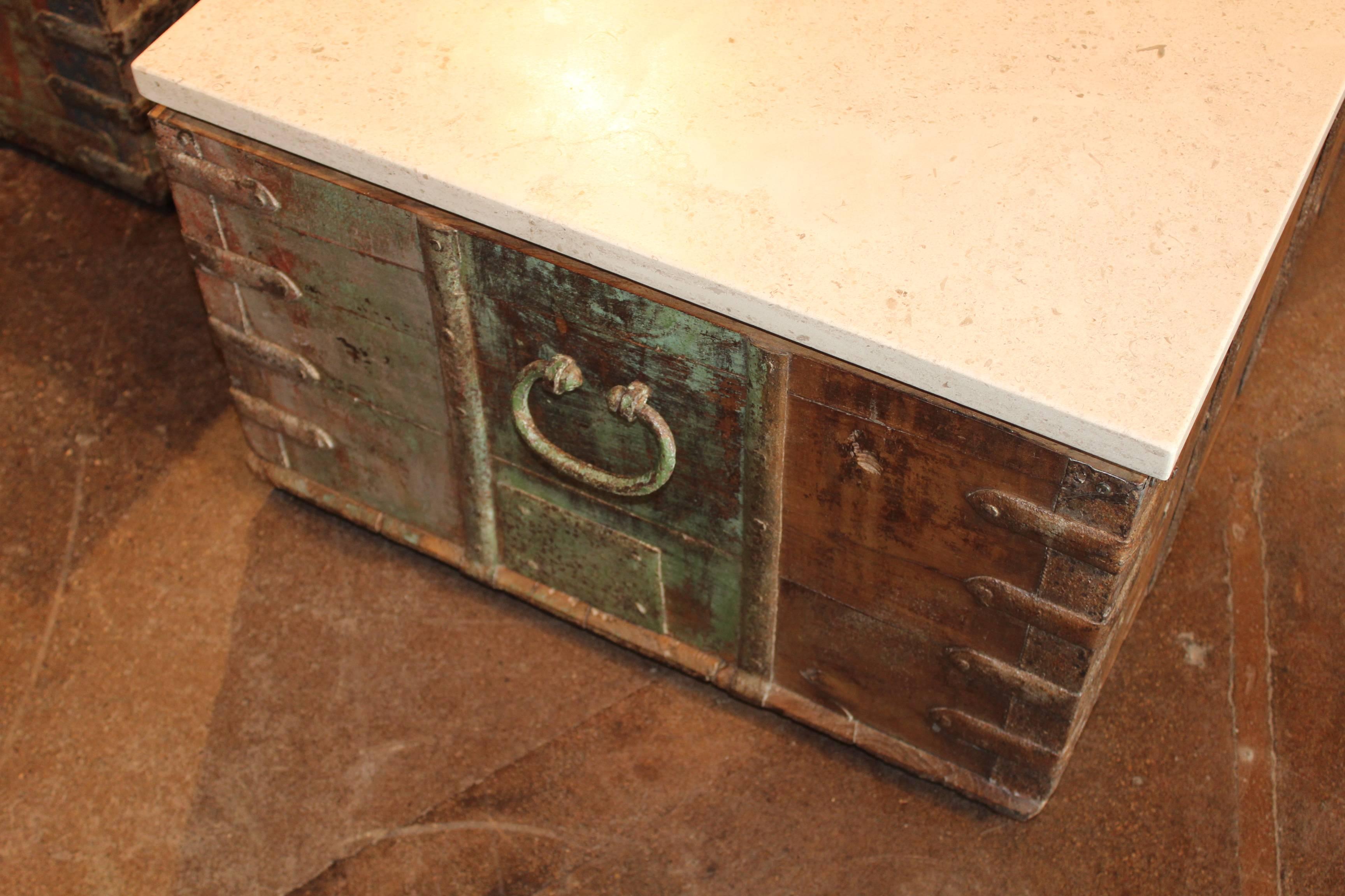 Antique trunk as coffee table with unusual strap hardware and limestone top.