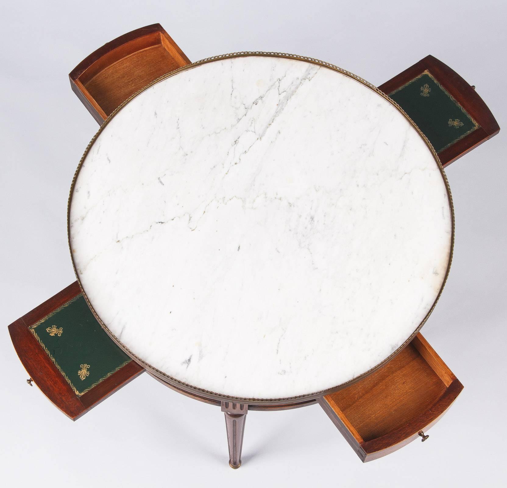A very attractive Louis XVI style "Bouillotte" coffee or side table made of cherrywood and topped with a white Carrara marble surrounded by a pierced brass gallery. The apron has two drawers with brass pulls and two pull-out shelves made