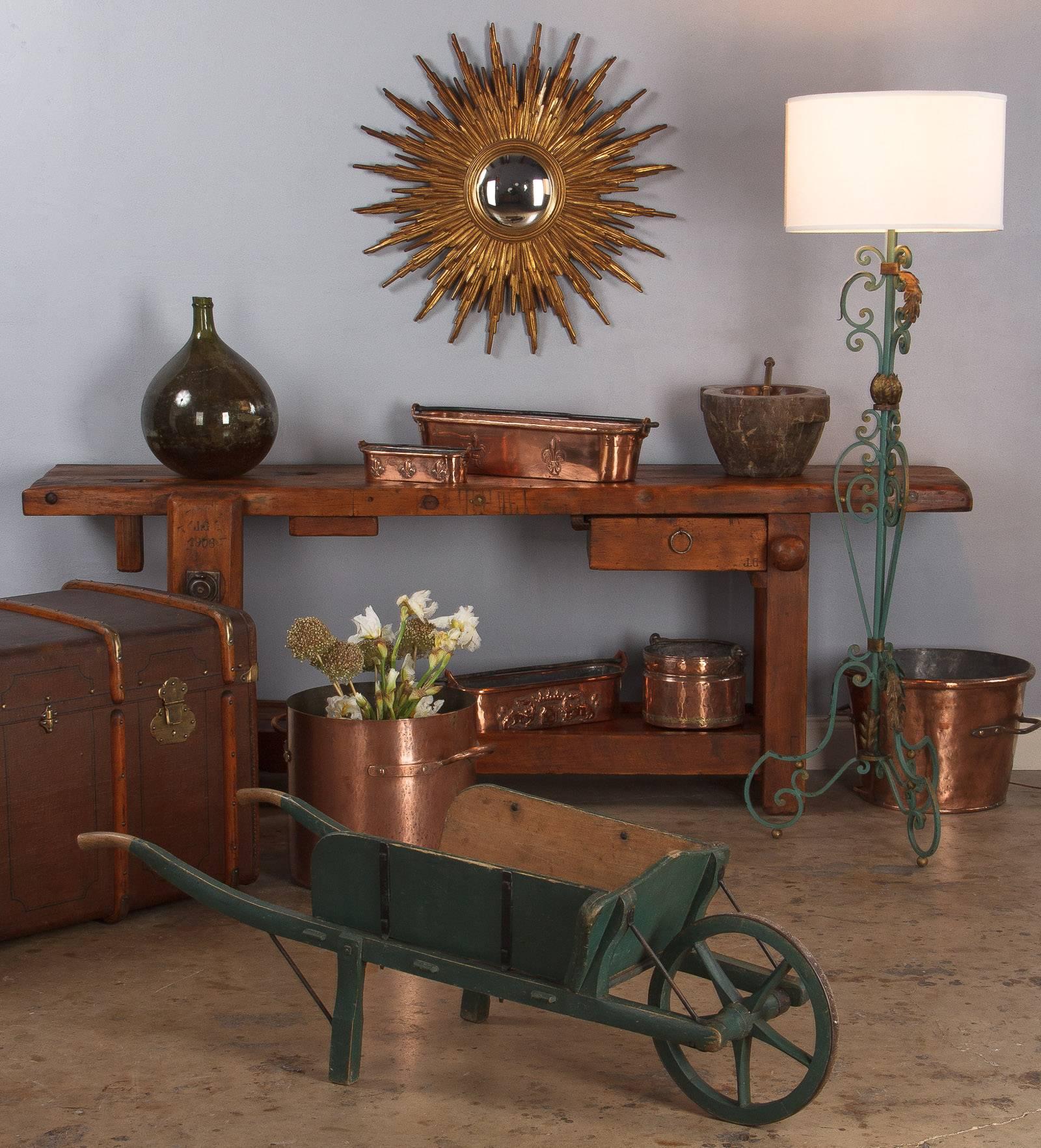 An antique wheelbarrow, decorative as well as in working condition, from the Bresse region of France, circa 1900s. It was painted forest green on pine and the wheel has an iron rim.