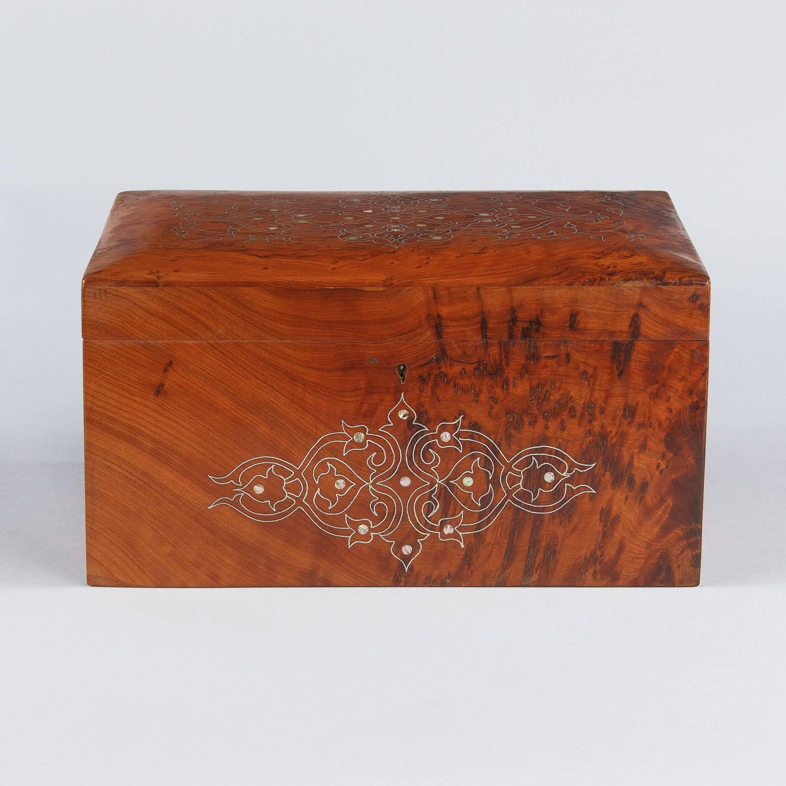 A gorgeous Charles X period jewelry box made of burl elmwood with mother-of-pearl marquetry inlay in arabesque shapes. The inside has a removable tray with three compartments. The original working key is included.