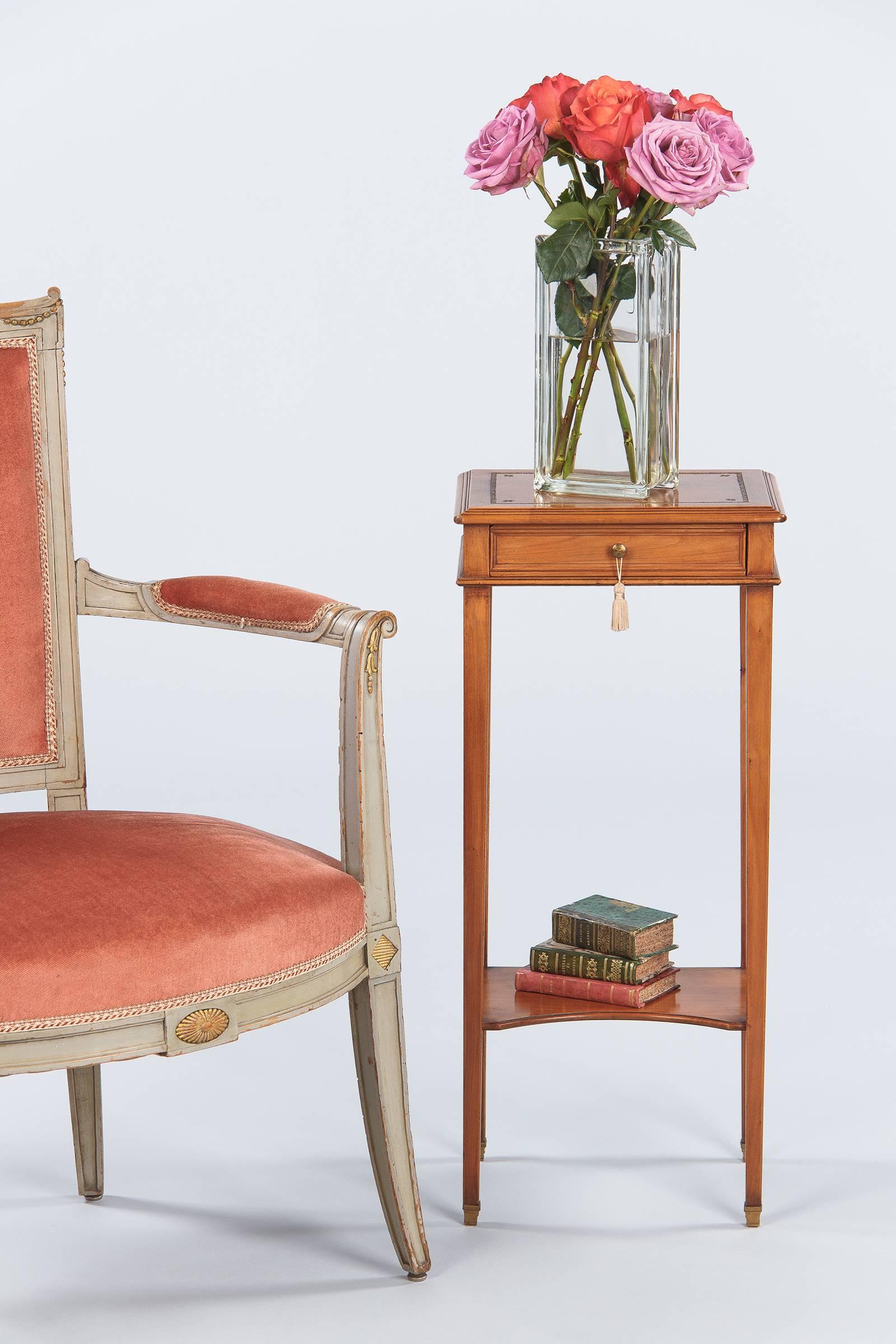 A charming small side table made of cherrywood in the Louis XVI style with an embossed tobacco leather top. The 12