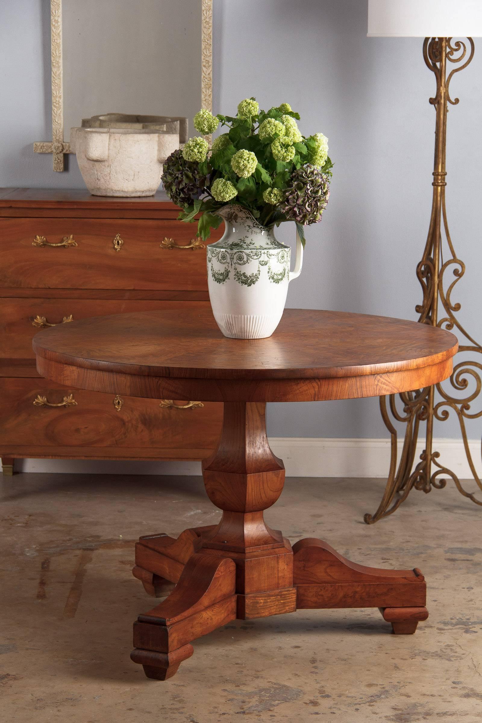 An outstanding pedestal table or gueridon from the Charles X period, early 1800s. Made from solid and burl ashwood, the table has a nice, warm tone throughout. The circular top has gorgeous bookplate veneer and a round inlay of satin wood at its