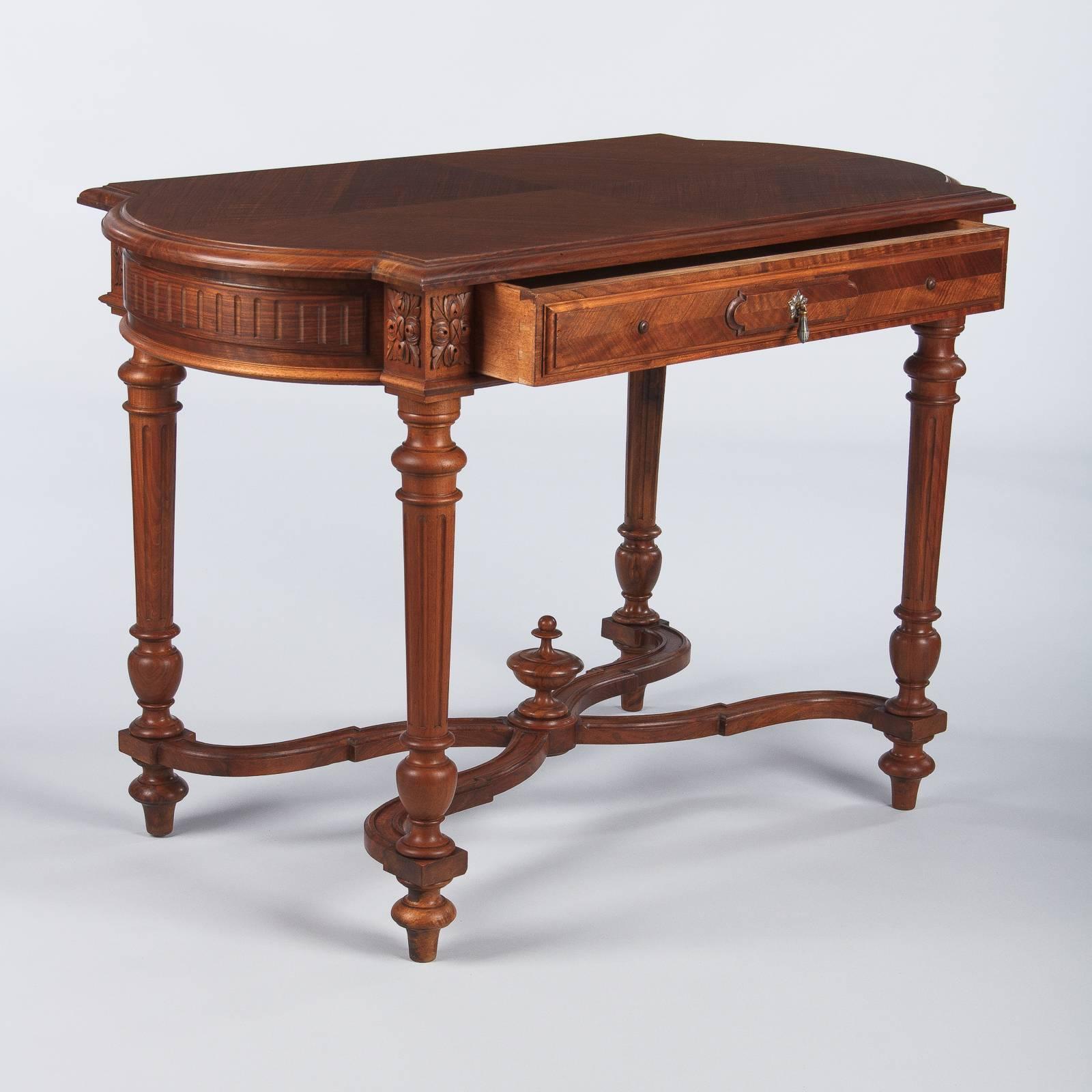 A dapper cherrywood Louis XVI style desk, circa 1900. Wonderful cherrywood veneer on top forms a tight series of concentric diamonds. Bowed sides give the piece a unique outline. The apron is fluted on the sides and has relief carved foliate