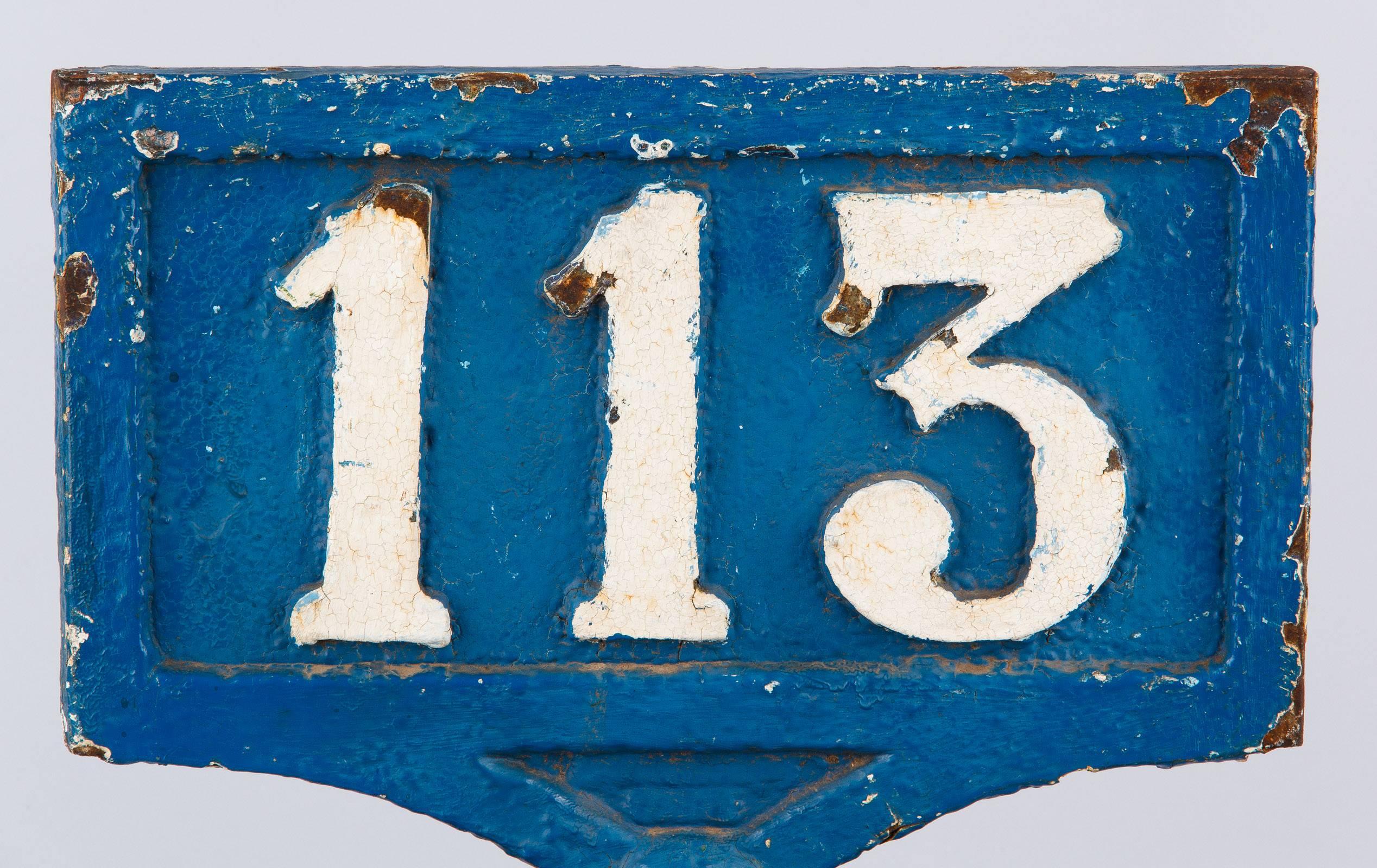 A 19th century French railway sign made of cast iron painted blue and white with the number 113. These signs were placed on top of posts to indicate the railway line number. The octagonal base has a small lip at the bottom and larger molded edge at