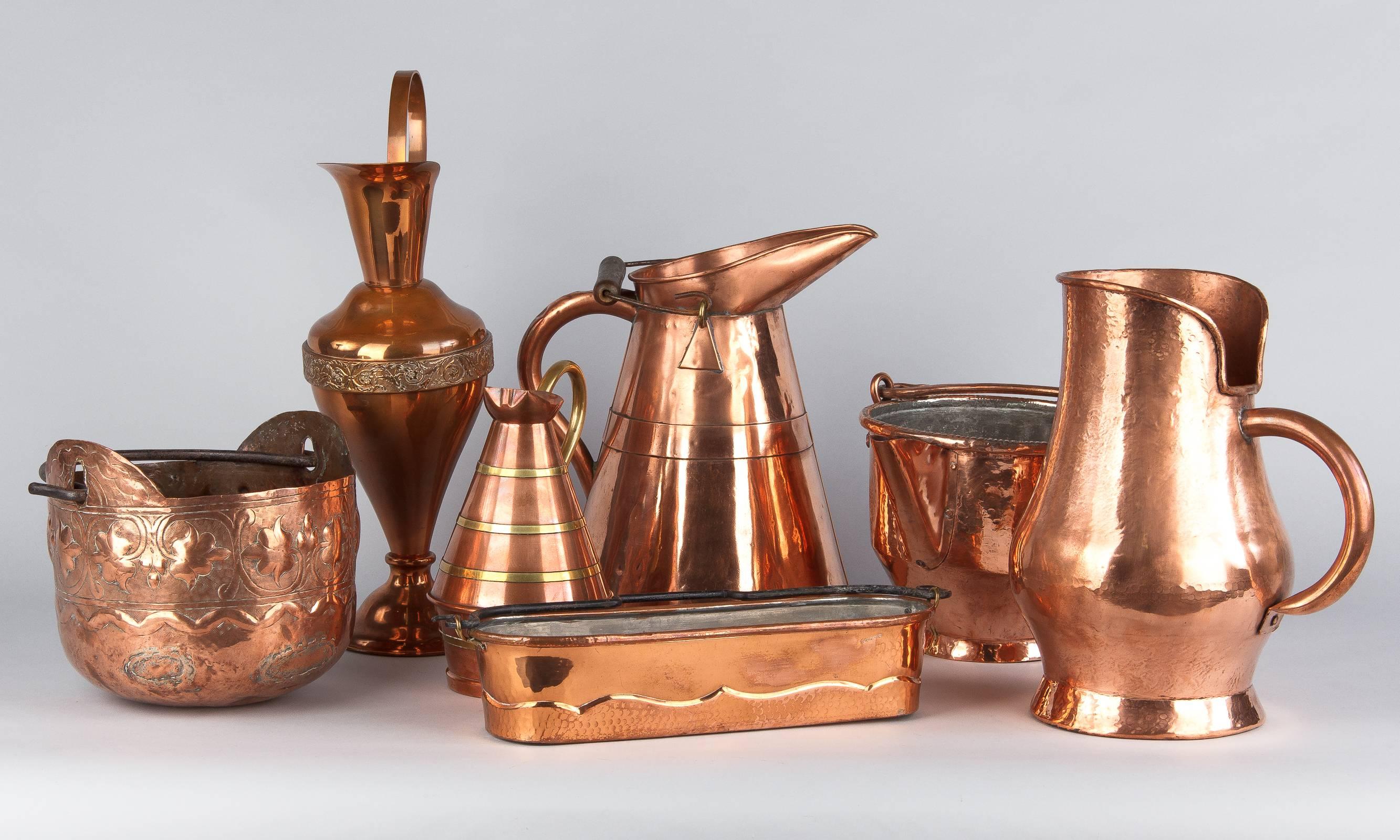 Vintage French copper and brass pitcher for wine and water, circa 1950. Two flared copper pieces are joined at their widest point, about one third of the way up the pitcher, creating a low belly. Four decorative bands of brass encircle the pot and a