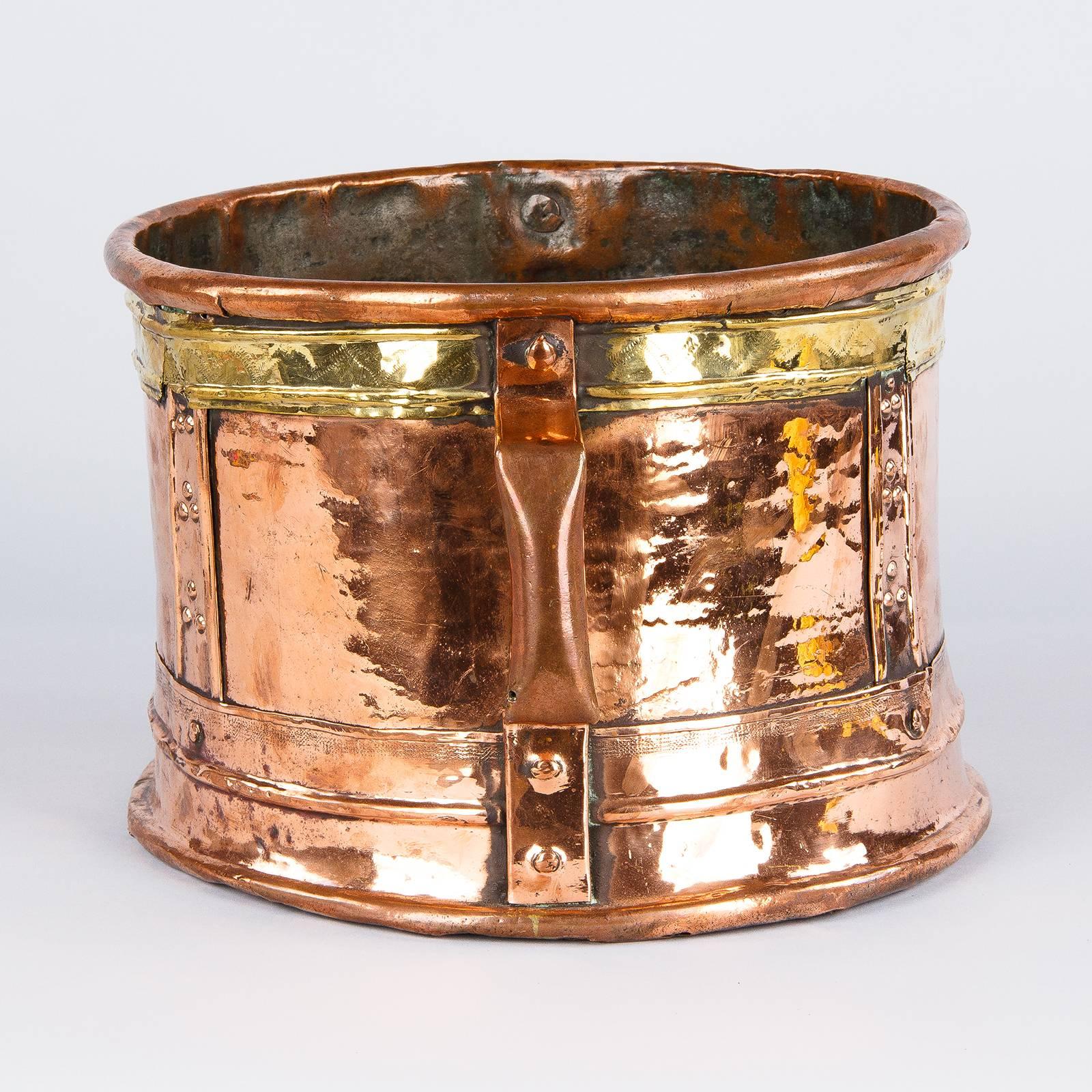 The Ferrat is a copper vessel that was use to measure grain or water. It originates from the Auvergne region of France. This copper Ferrat with brass accents and 2 handles can be dated back to the 18th century. A beautiful decorative piece that can
